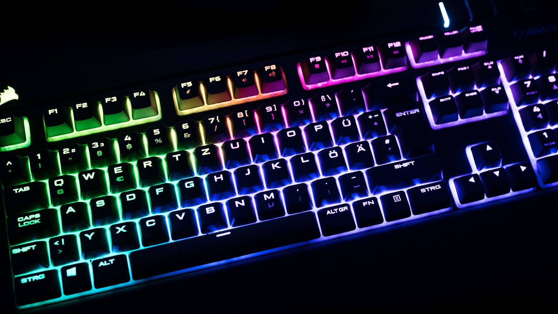 Rgb 桌布 壁紙 — 特寫一個遊戲鍵盤，在黑暗背景下發出鮮豔的彩虹背光。