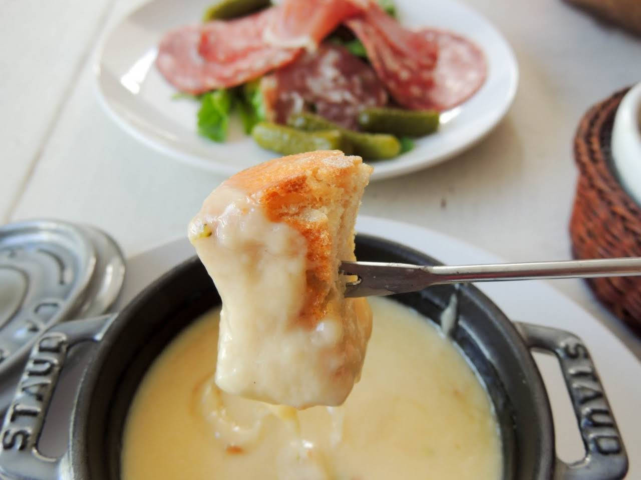 Cheese 桌布 壁紙 — 特寫一個酥脆的麵包塊，滴著來自Staub鍋的奶油融化起司，配以醃肉和青豆。