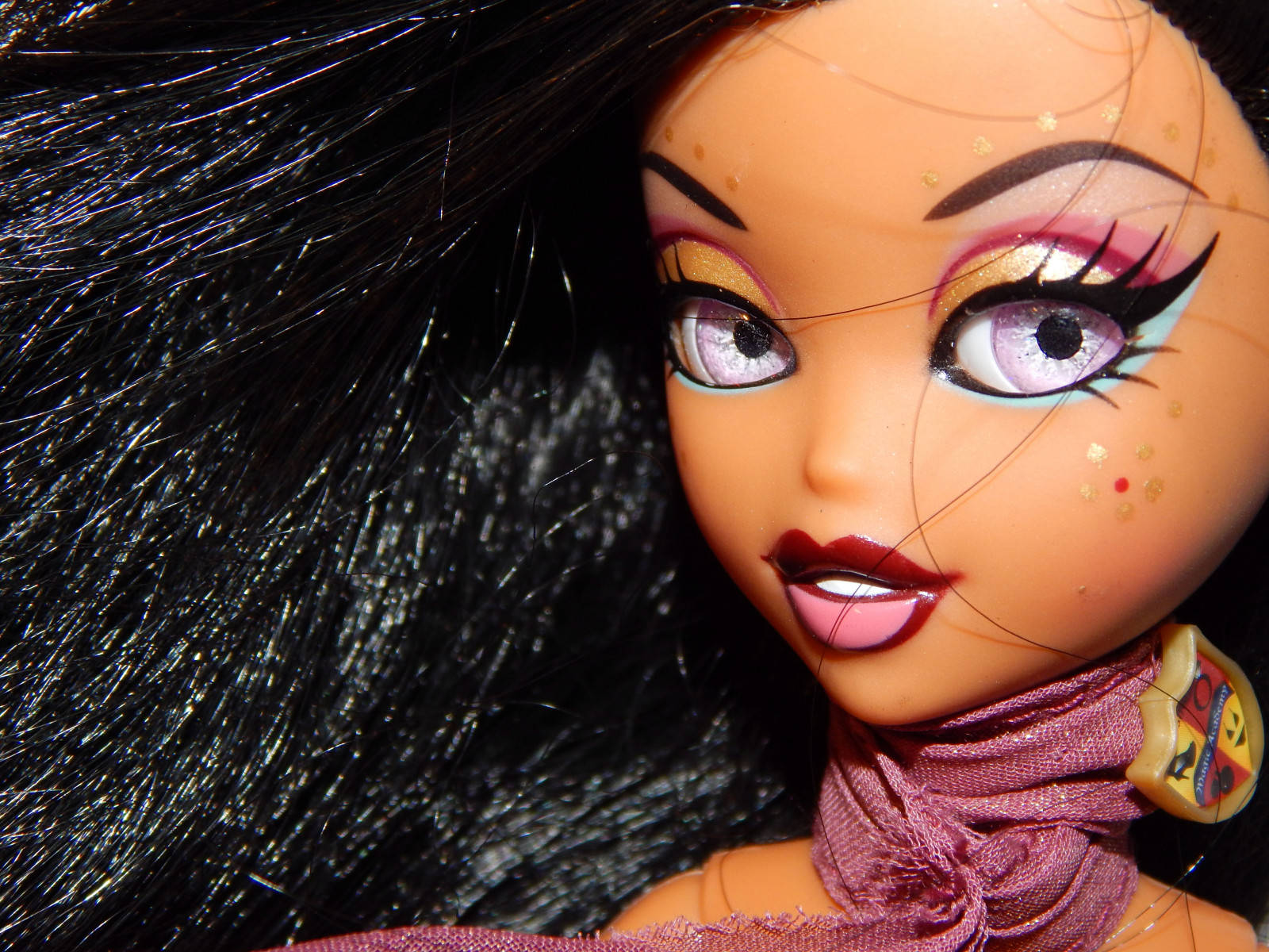 Bratz 桌布 壁紙 — 特寫一個長黑髮、閃亮紫色眼睛、大膽化妝的娃娃，戴著紫色圍巾。