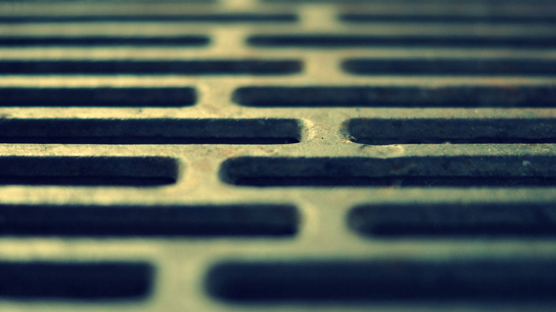 金屬質感 桌布 壁紙 — 特寫一個風化金屬排水格柵，淺景深，柔和青綠色調。