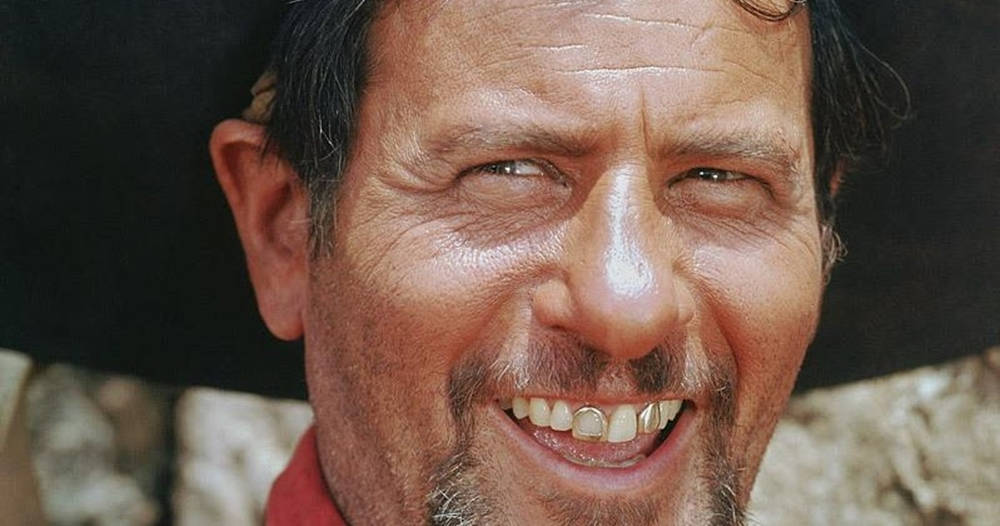 Celebrity 桌布 壁紙 — 特寫一個飽經風霜的男人，在深色帽子下露出燦爛笑容，展示金牙。