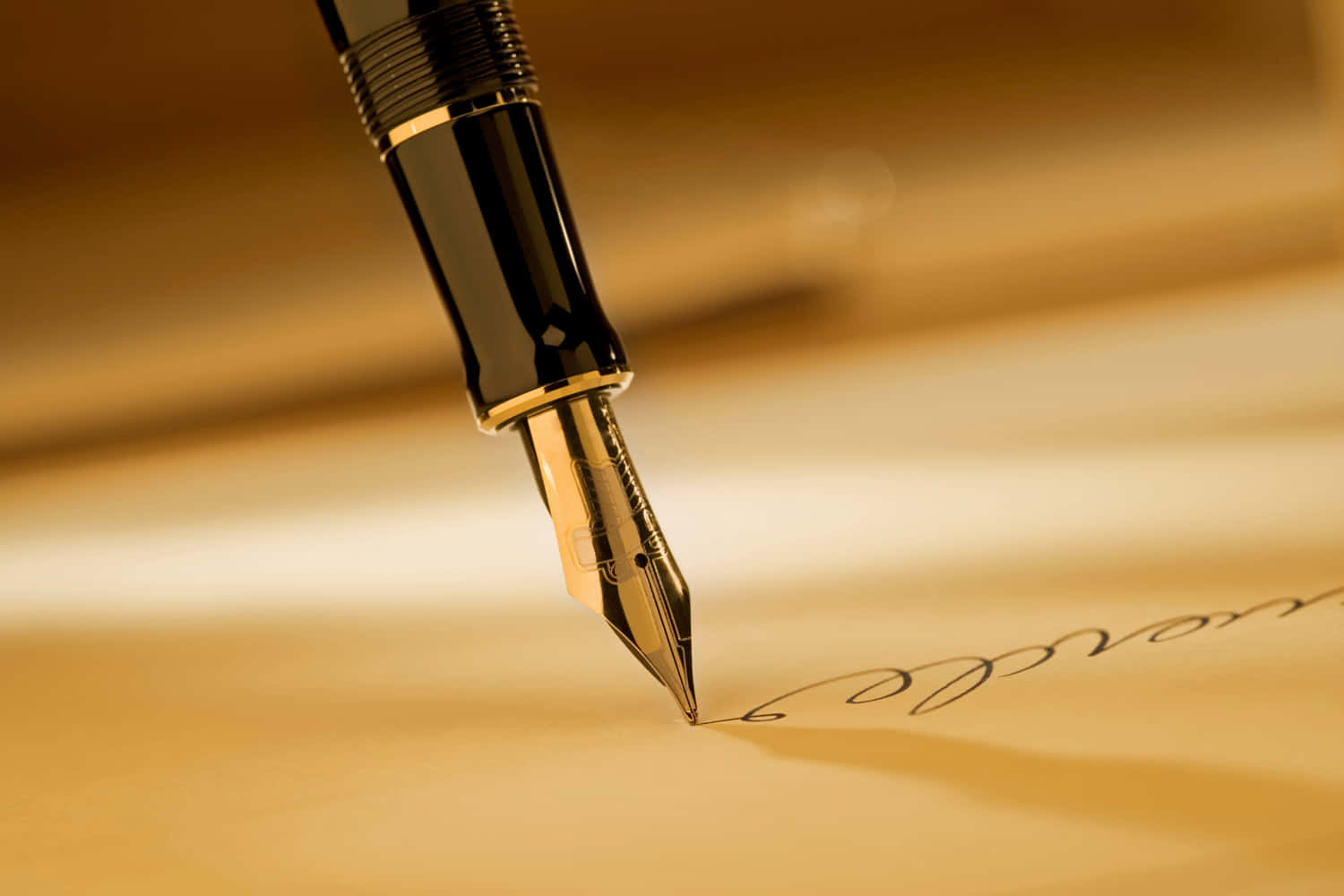 Pen 桌布 壁紙 — 特寫一支黑色和金色的鋼筆在暖色調羊皮紙上書寫優雅的草書。