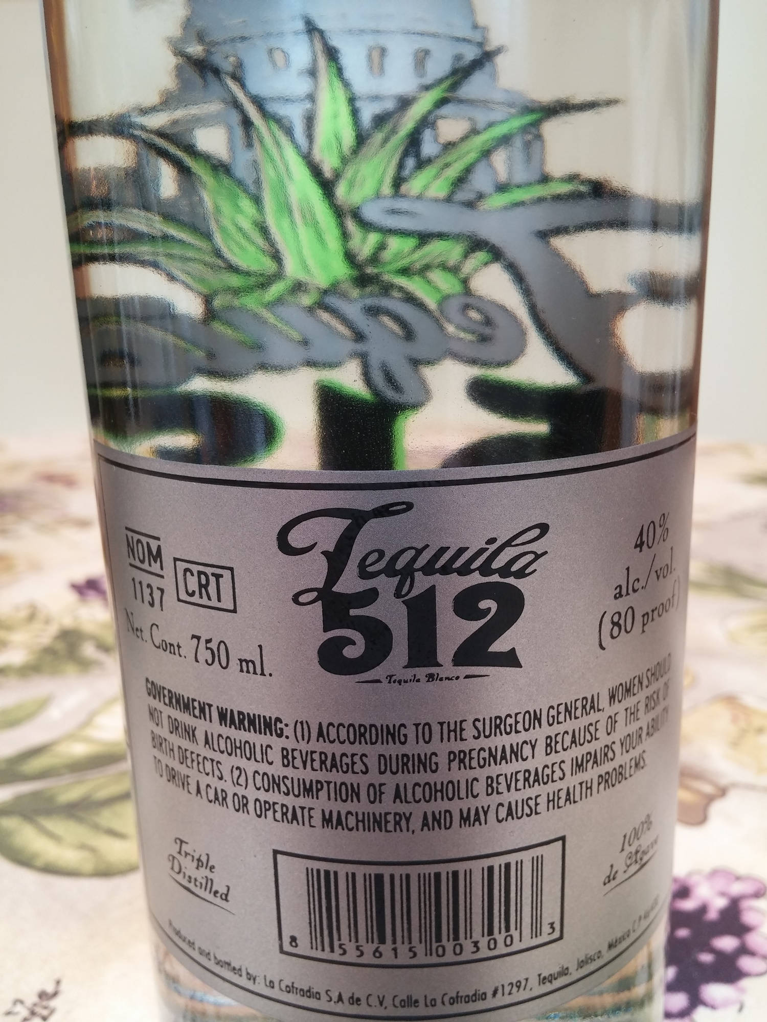 drinks 桌布 壁紙 — 特寫一瓶標有 'Tequila 512' 的龍舌蘭酒瓶，帶有風格化的綠色龍舌蘭植物和國會大廈插圖。