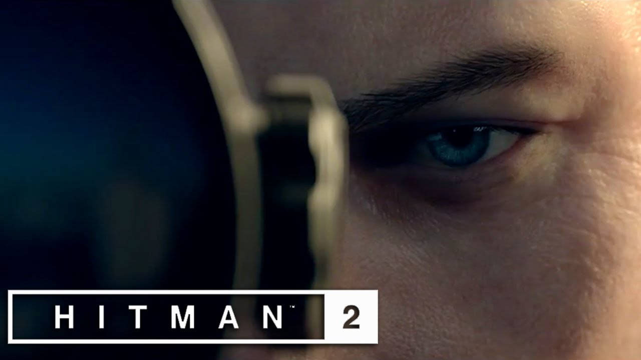 桌布 壁紙 — 特寫一隻銳利的藍眼睛透過步槍瞄準鏡窺視，並可見 'HITMAN 2' 標誌。