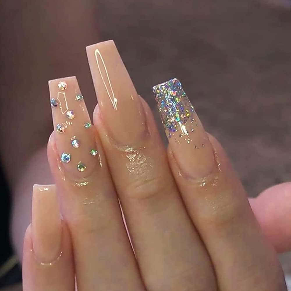 Fake Nail 桌布 壁紙 — 特寫優雅修飾的長杏仁形指甲，裸色基底飾有水鑽和亮粉。