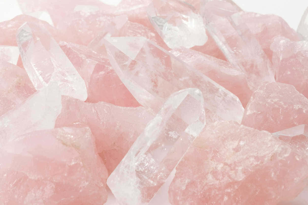 Healing Crystals 桌布 壁紙 — 特寫半透明粉紅玫瑰石英晶體，具有銳利切面和柔和粉彩色調，背景為亮白色。