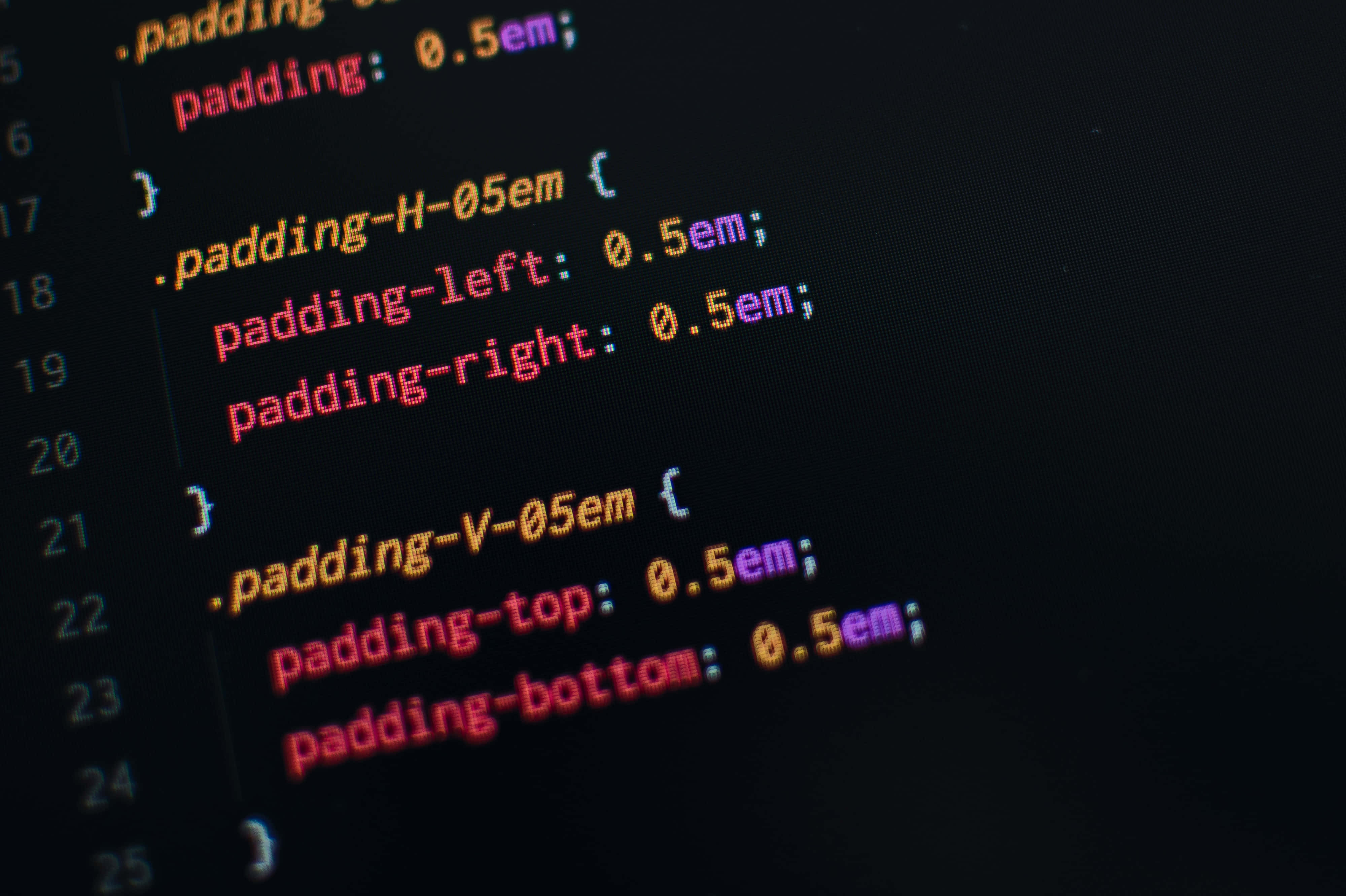 Code 桌布 壁紙 — 特寫發光多彩的CSS程式碼行在黑暗螢幕上顯示padding屬性。