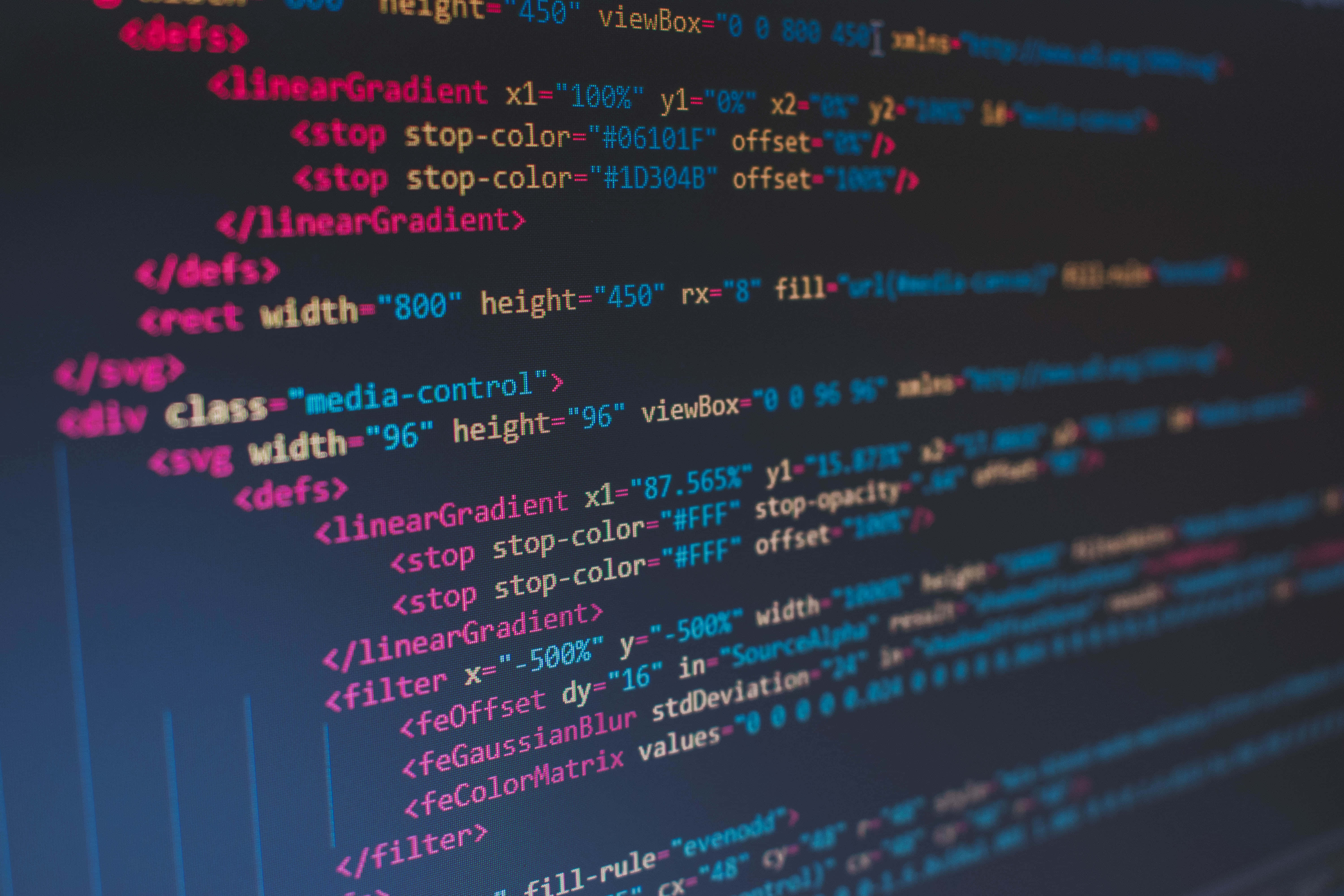 4K程式壁紙 桌布 壁紙 — 特寫發光多彩的HTML CSS程式碼行在黑暗螢幕上，背景模糊。