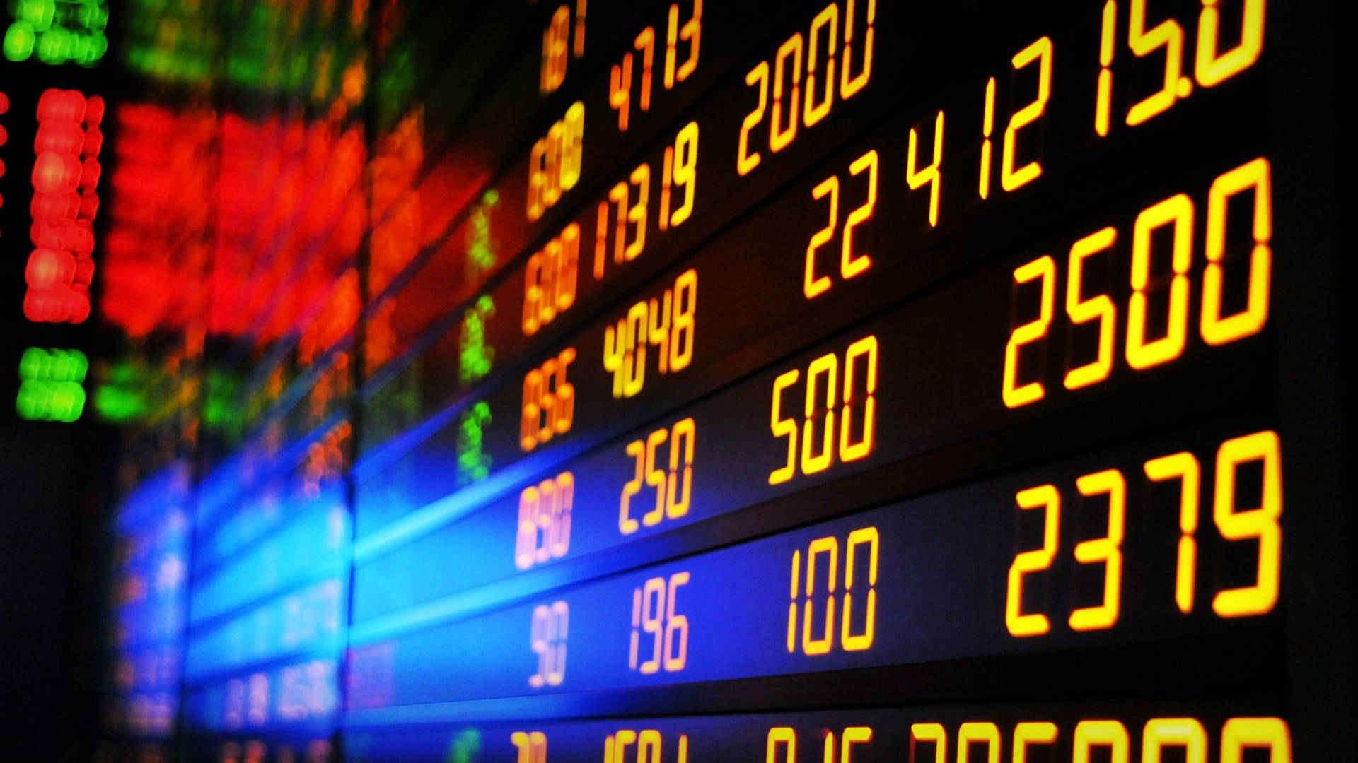 Market 桌布 壁紙 — 特寫發光數位股票行情顯示器，在深色背景上以紅色、綠色和黃色顯示財務數據。