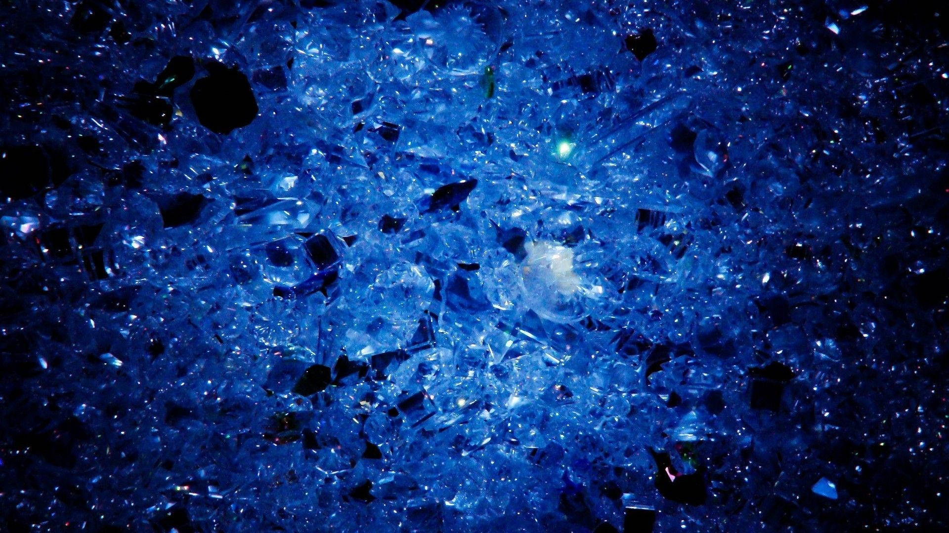 水晶 桌布 壁紙 — 特寫破碎的藍色玻璃碎片在黑暗背景中發光。