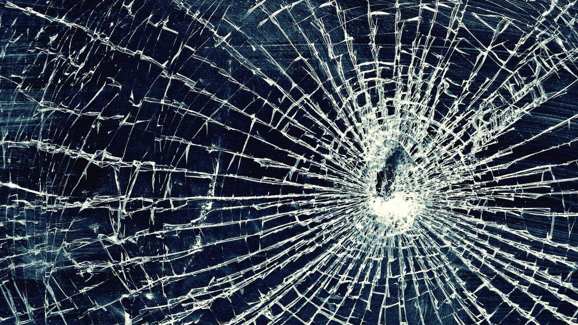 broken monitor 桌布 壁紙 — 特寫碎裂玻璃，中央撞擊點向外輻射裂紋，背景為深藍色。