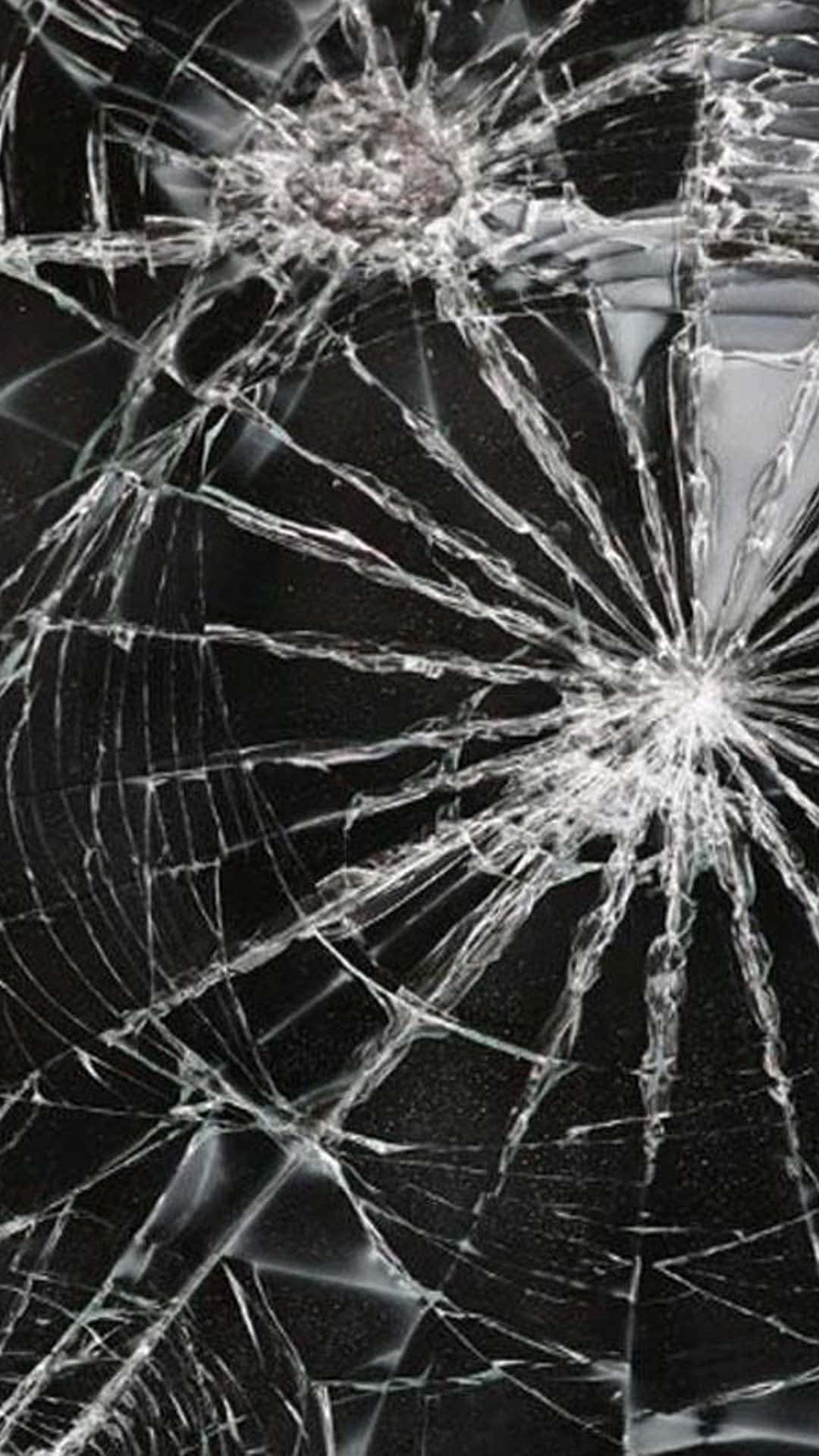 iPhone 桌布 壁紙 — 特寫碎裂玻璃，裂紋從撞擊點向四周擴散，背景為深色。