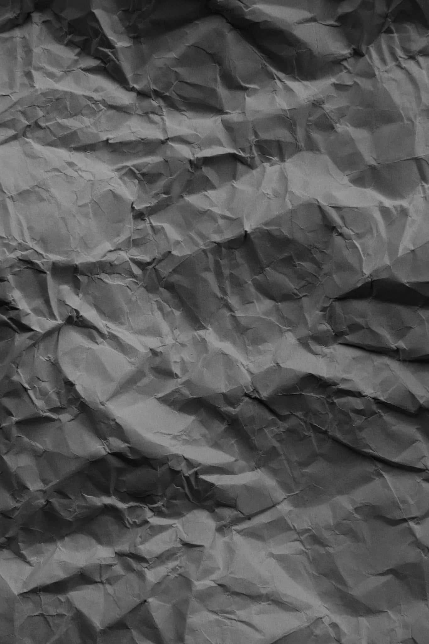 texture 桌布 壁紙 — 特寫紋理皺摺灰色紙張，深色陰影與高光營造出觸覺抽象表面。