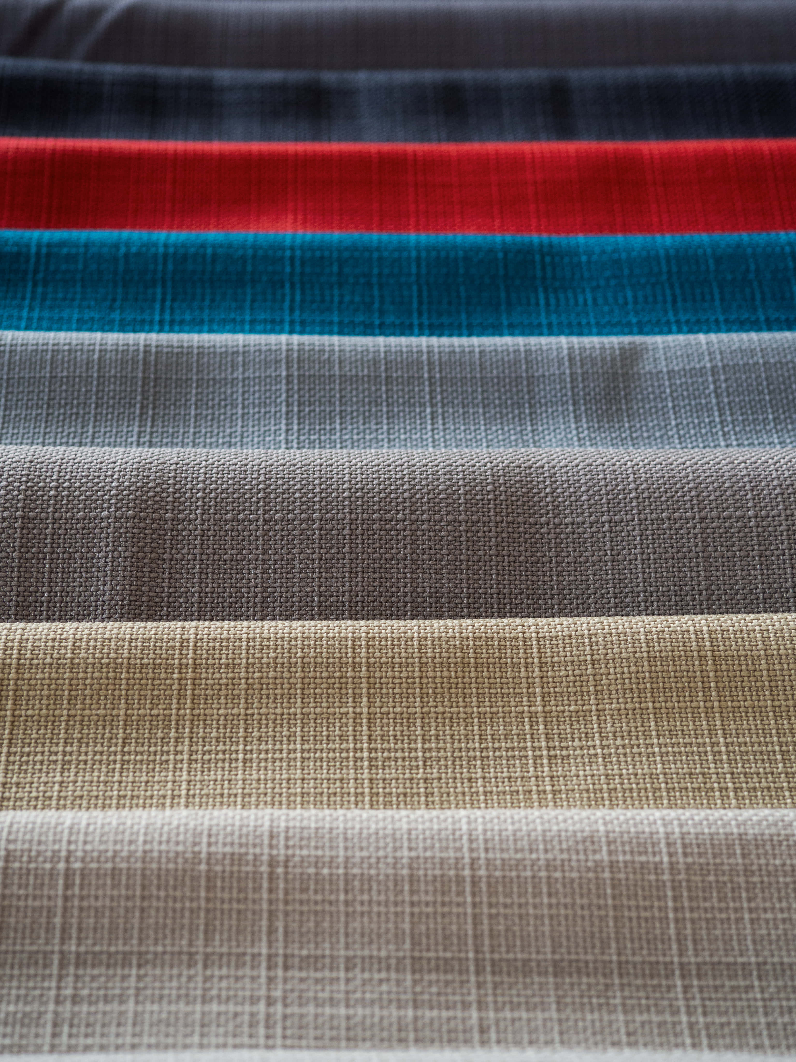 Fabric 桌布 壁紙 — 特寫紋理織物條紋，呈現大膽的紅色、藍綠色、灰色、米色和黑色水平帶狀。