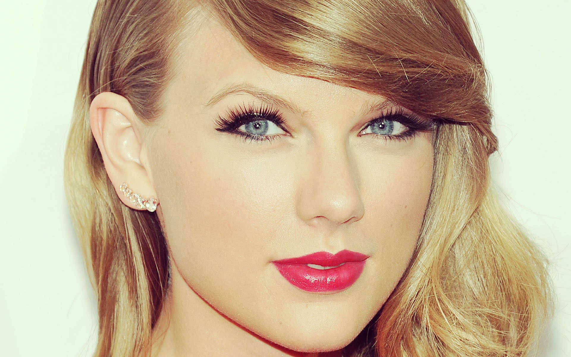Taylor Swift 桌布 壁紙 — 特寫肖像，一位金髮碧眼、紅唇大膽的女性，背景為柔和的白色。