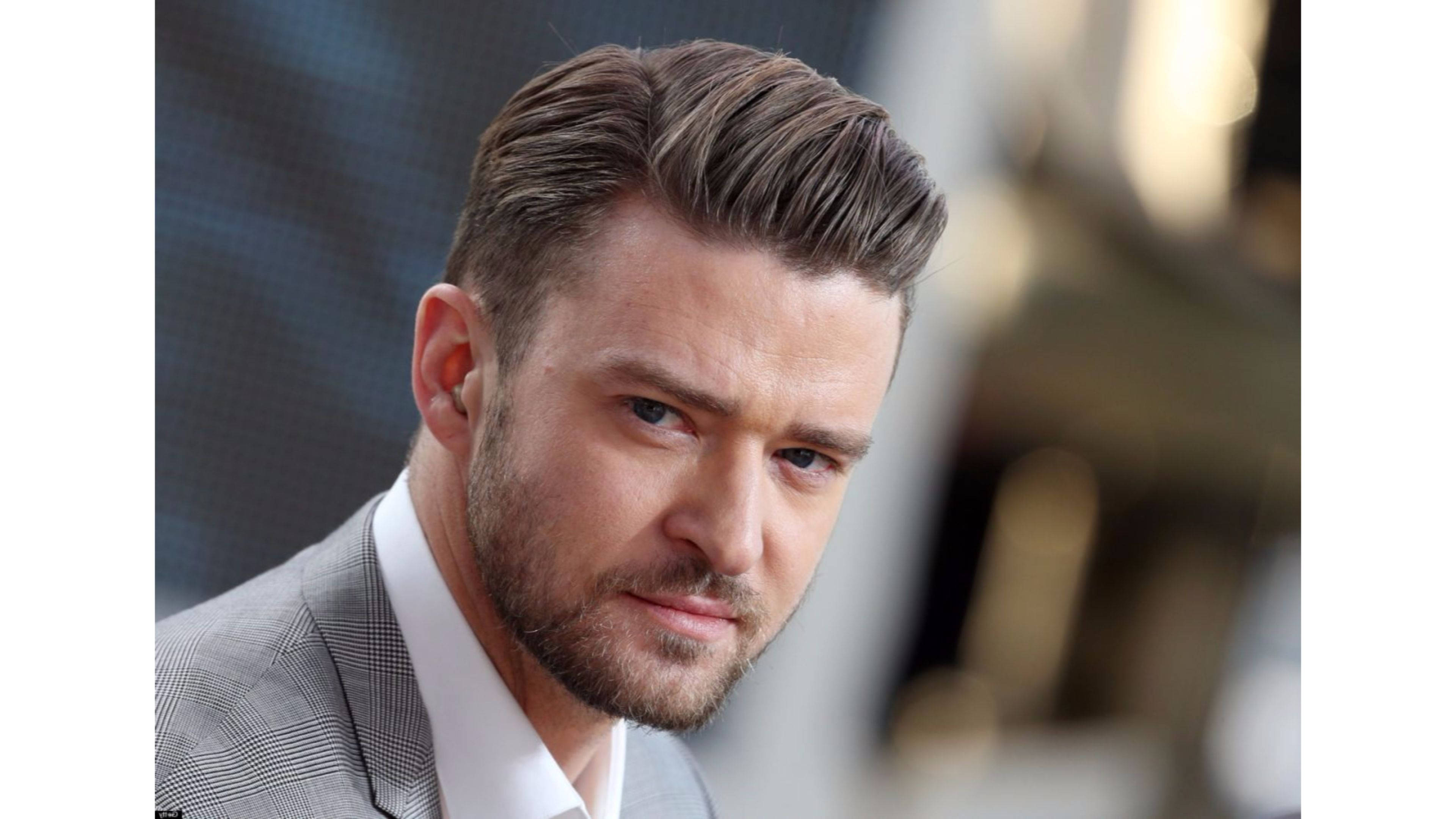 justin timberlake 桌布 壁紙 — 特寫肖像，一名男子留著造型頭髮和鬍鬚，身穿灰色西裝，背景模糊。