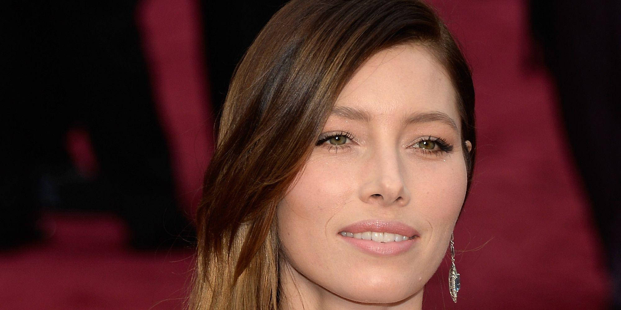jessica biel 桌布 壁紙 — 特寫肖像照，一位棕色頭髮、綠色眼睛的女性在紅色地毯上溫柔微笑。
