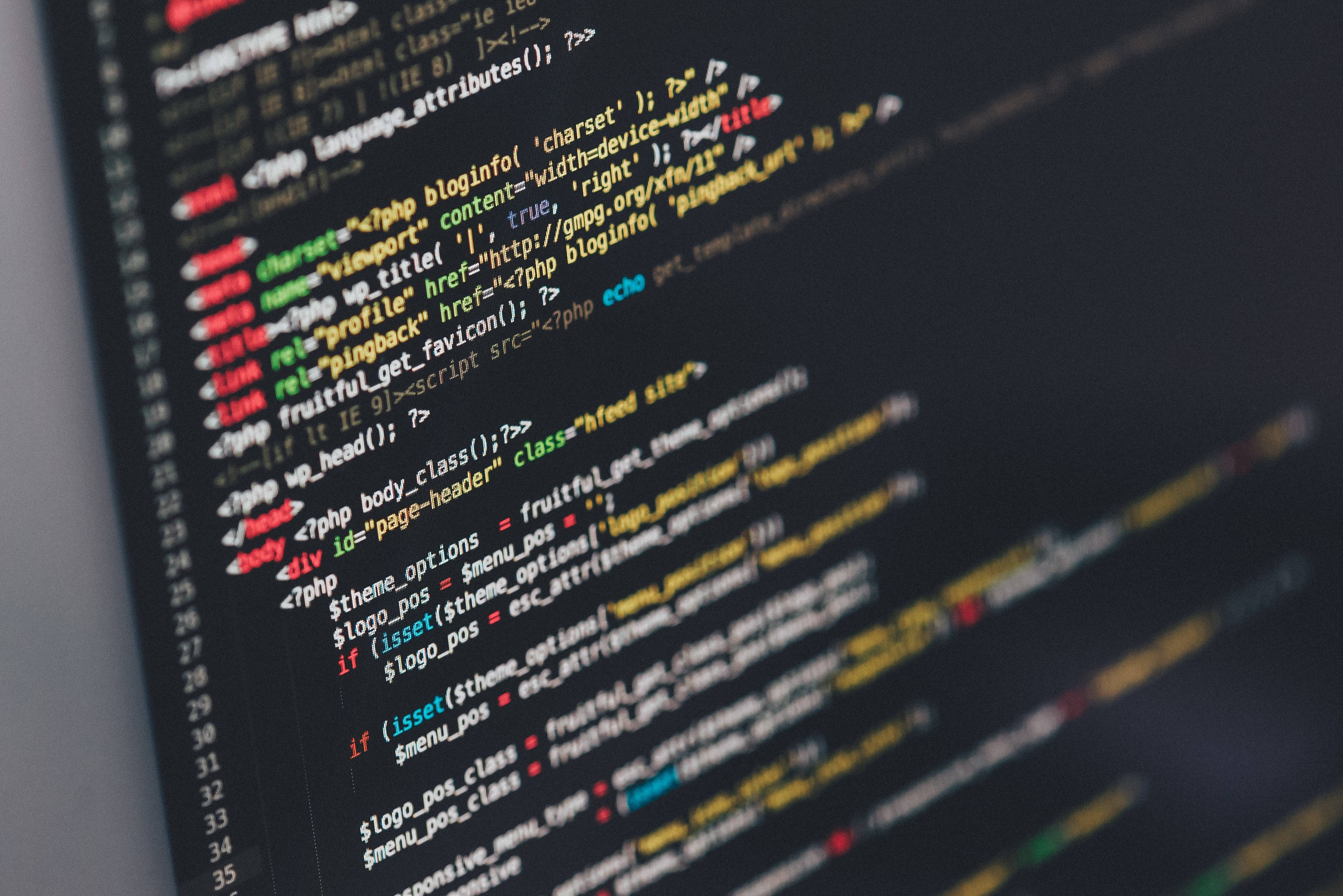 Coder 桌布 壁紙 — 特寫色彩繽紛的PHP和HTML程式碼在黑暗螢幕上滾動，背景模糊。