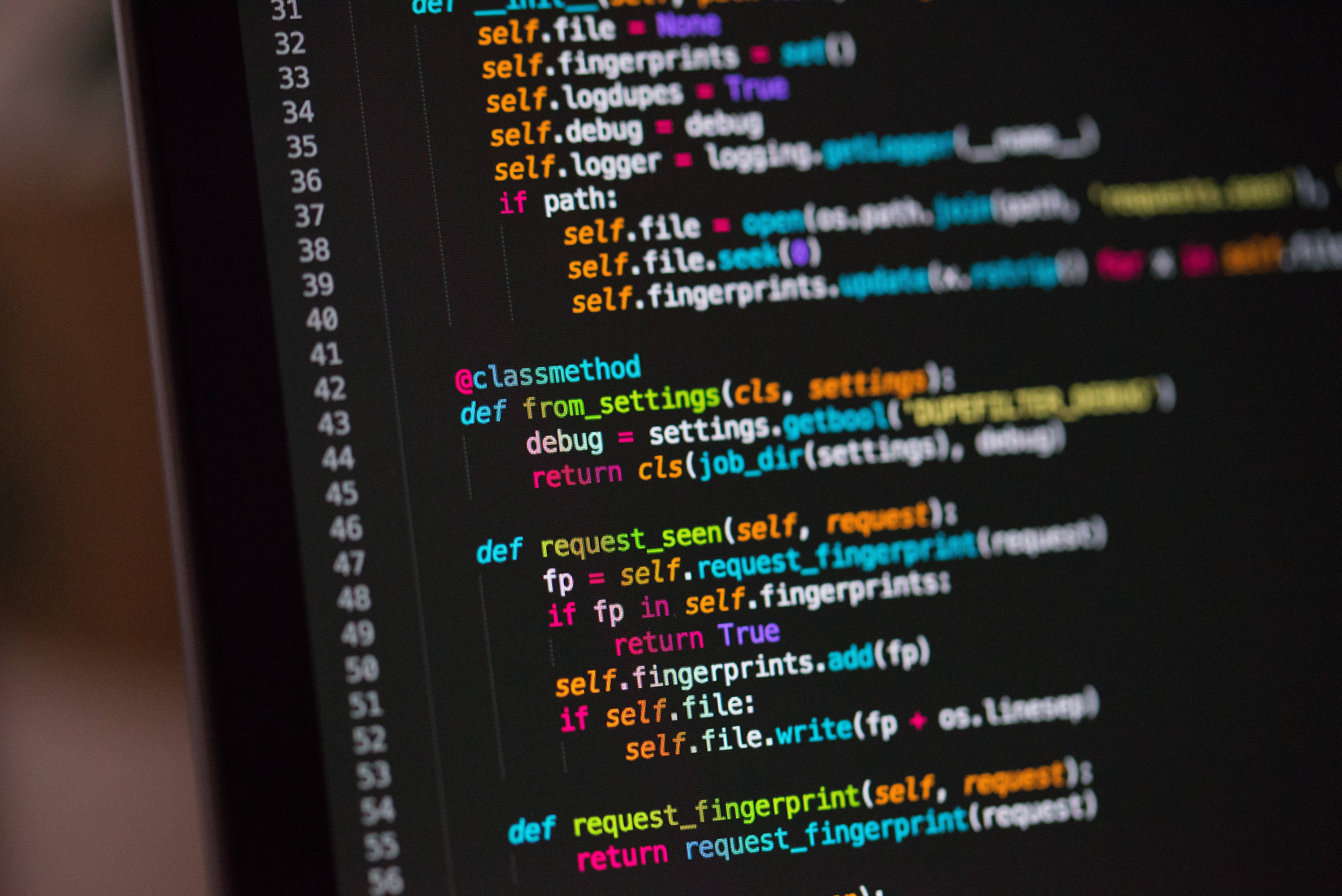 程式設計 桌布 壁紙 — 特寫色彩繽紛的語法高亮 Python 程式碼在深色螢幕上滾動，背景模糊。