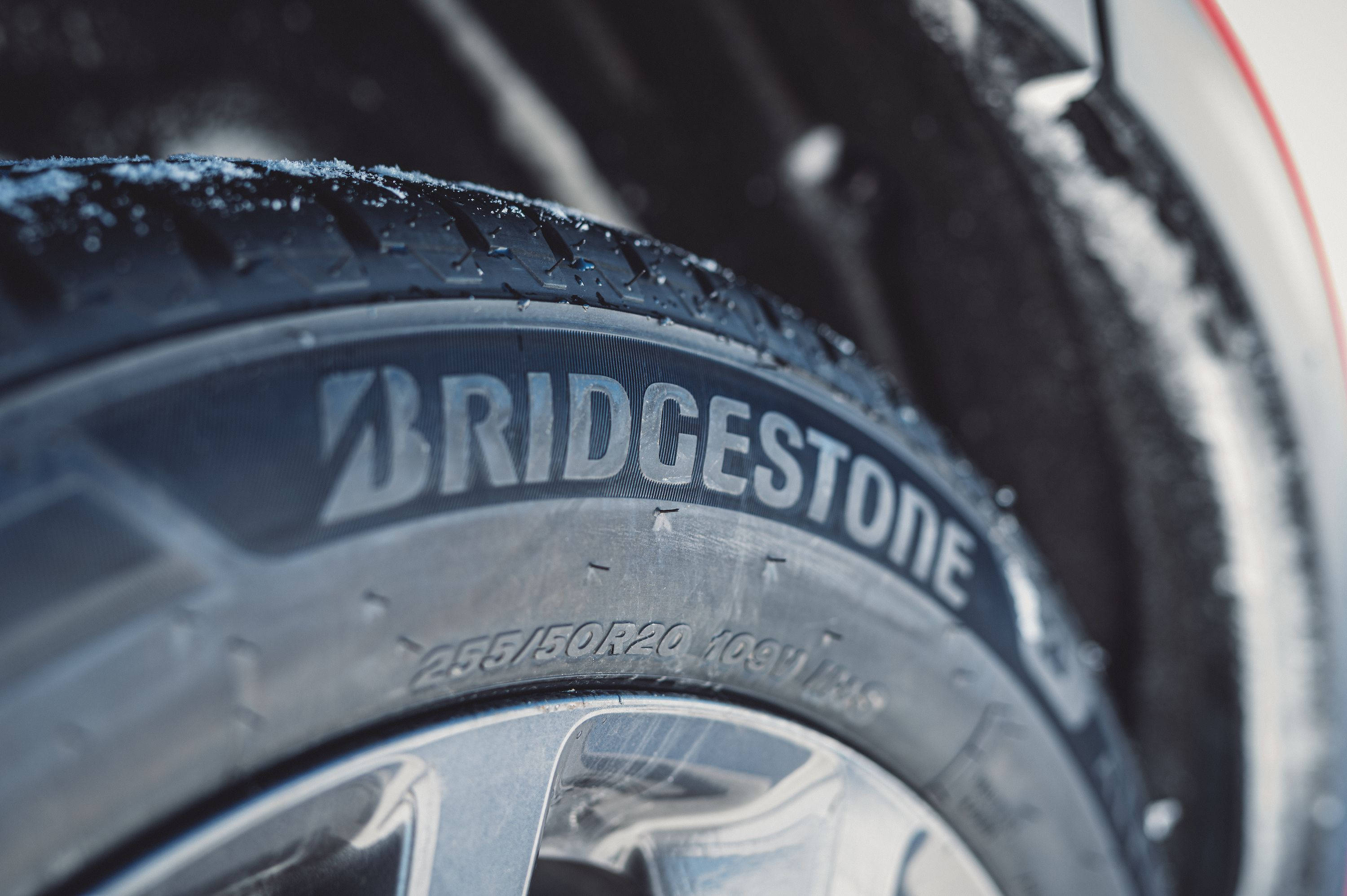 標誌 桌布 壁紙 — 特寫鏡頭：Bridgestone 輪胎在強光下，胎面和輪輞上附著雪花。