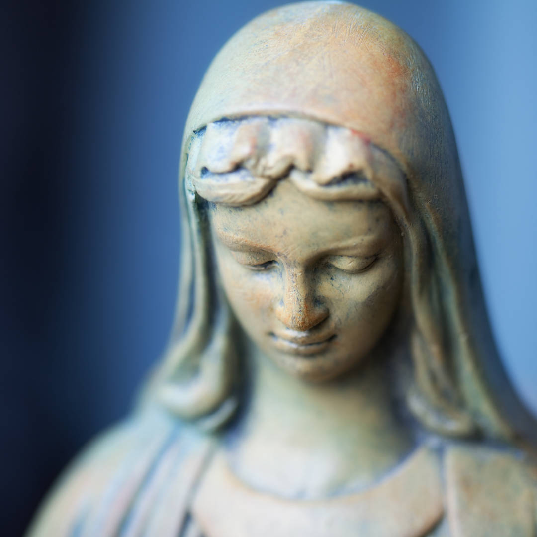 Catholic 桌布 壁紙 — 特寫鏡頭：一位閉目、披著輕紗的女性石像，襯以柔和藍色背景，氣氛寧靜。