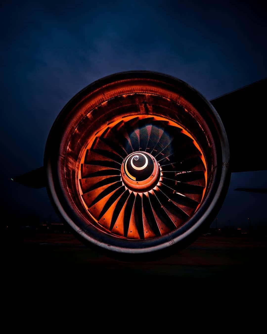 Jet Engine 桌布 壁紙 — 特寫鏡頭：一個噴射引擎在昏暗暮色天空中發出火橙色光芒。