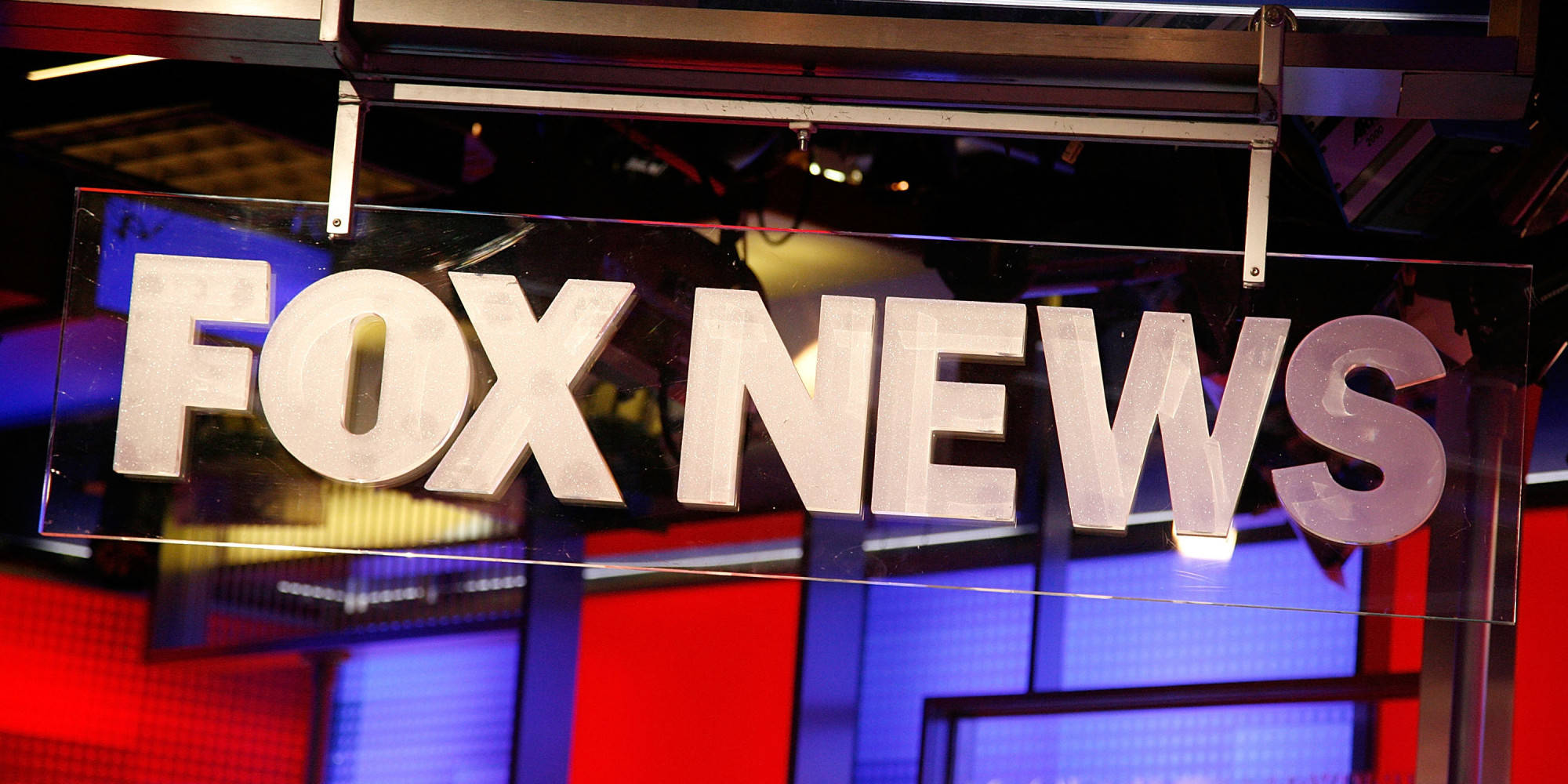 News 桌布 壁紙 — 特寫鏡頭：一個在紅藍燈光工作室中發光的 FOX NEWS 標誌。