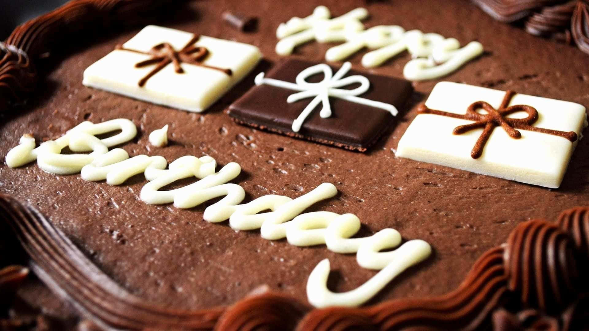 Birthday Cakes 桌布 壁紙 — 特寫鏡頭：一個豐富的巧克力生日蛋糕，裝飾著白色糖霜字母和巧克力禮物盒。