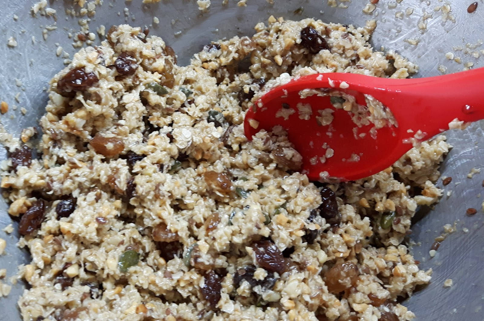 烹飪 桌布 壁紙 — 特寫鏡頭：一個金屬碗中，用紅色湯匙攪拌含有葡萄乾和堅果的燕麥混合物。