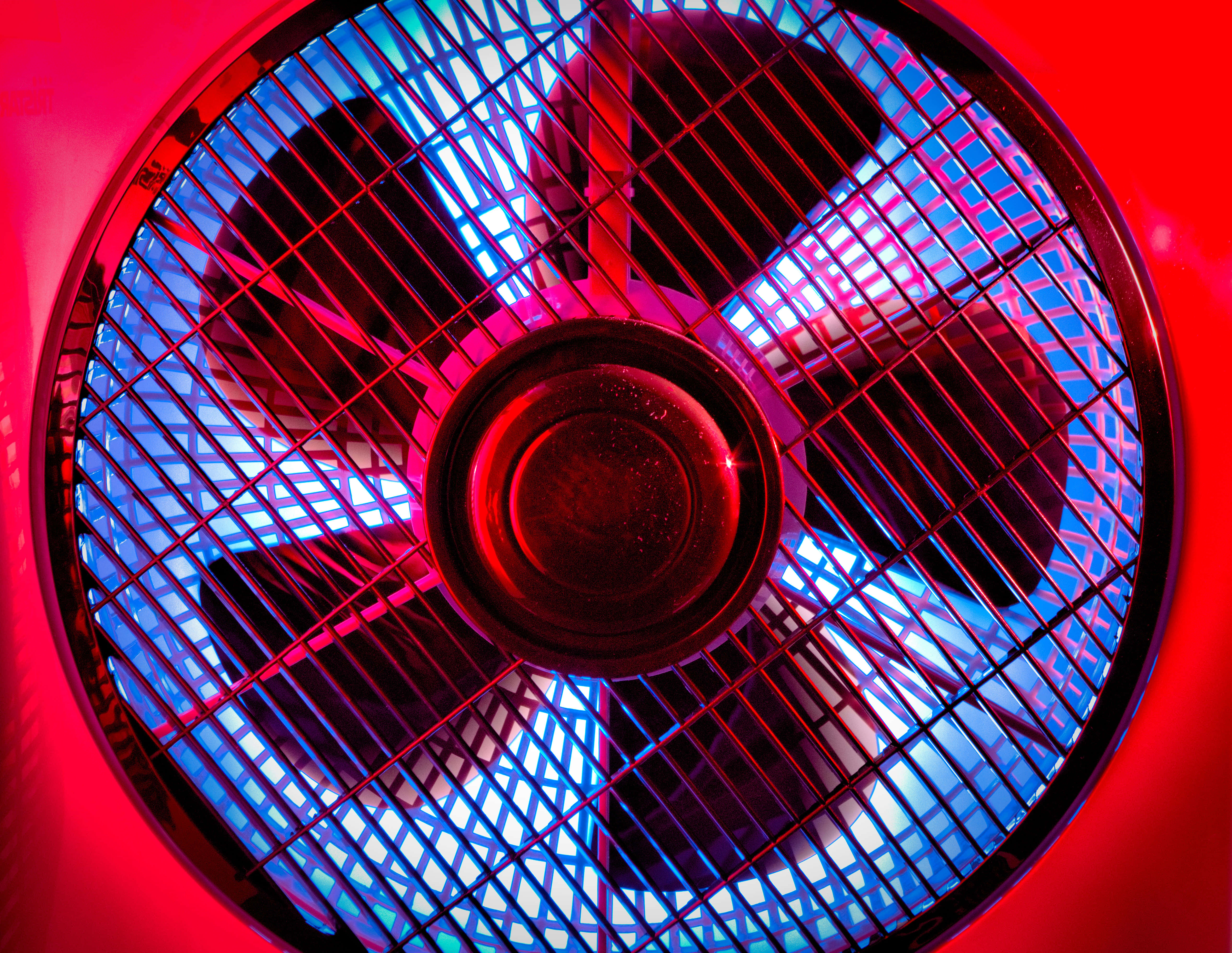 fan 桌布 壁紙 — 特寫鏡頭，一個風扇透過保護格柵發出鮮豔的紅色和藍色光芒。