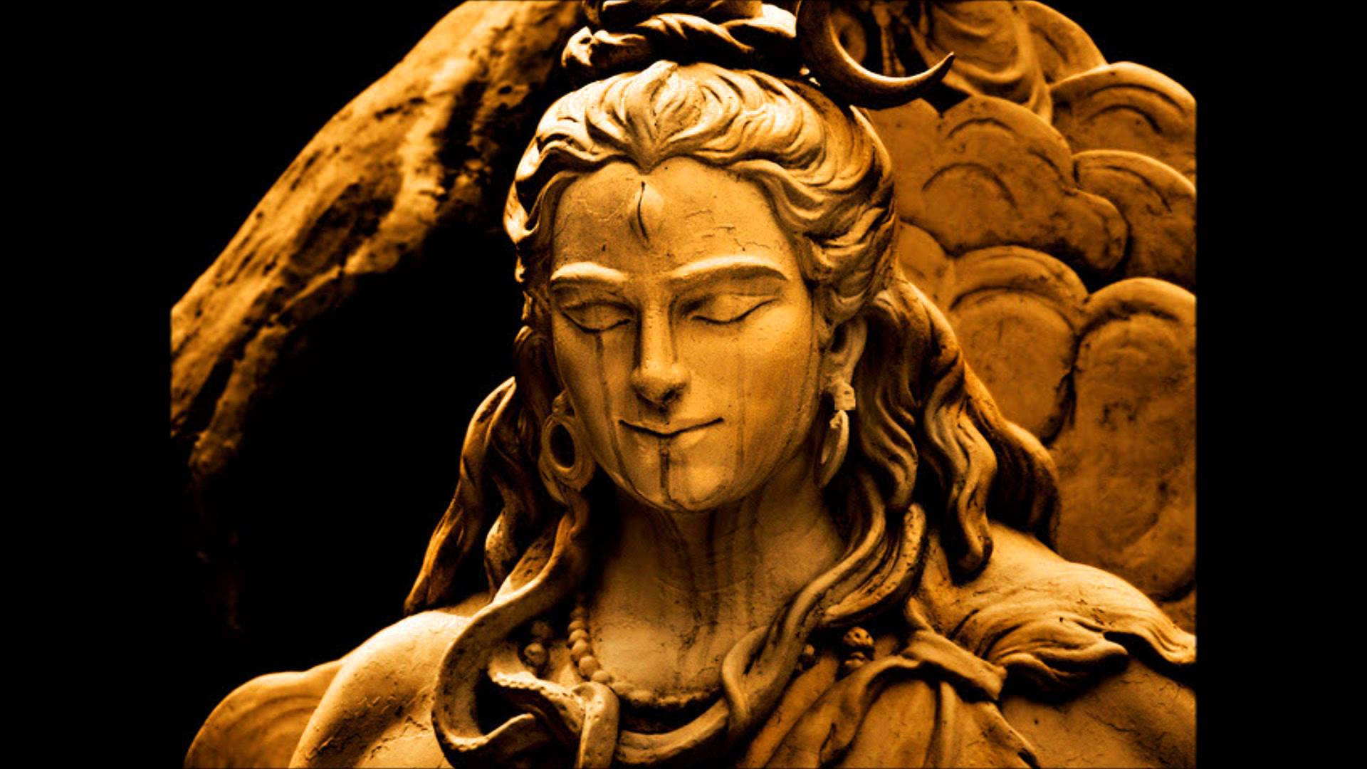 statue 桌布 壁紙 — 特寫鏡頭：一尊閉眼戴新月冠的神明石像，襯以深色背景，氣氛寧靜。