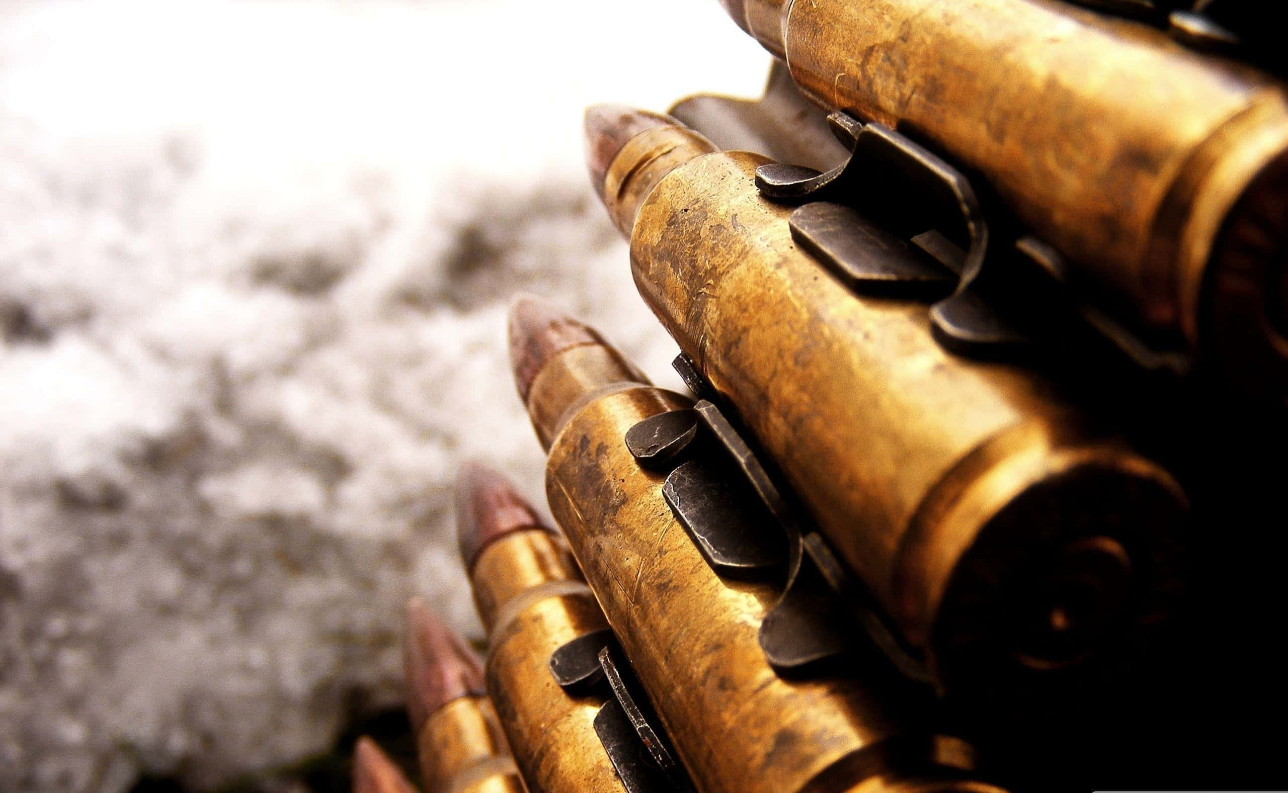 weapon 桌布 壁紙 — 特寫鏡頭：一條皮帶上的風化黃銅步槍子彈，背景是模糊的雪景。