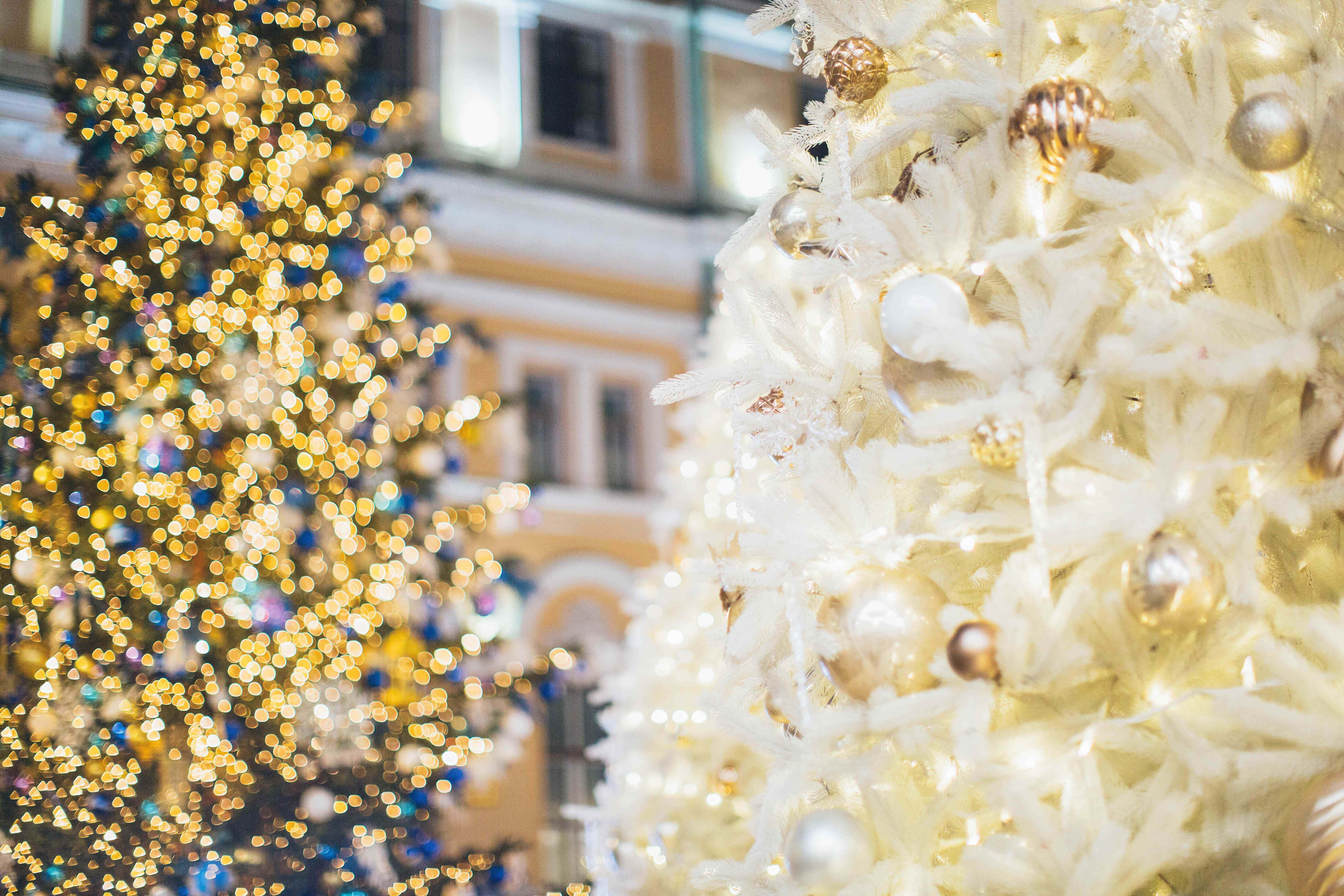 Christmas Ornament 桌布 壁紙 — 特寫鏡頭：一棵白色羽毛聖誕樹，飾有金色裝飾和柔和燈光，背景是模糊的金色散景。