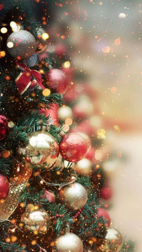聖誕美學 桌布 壁紙 — 特寫鏡頭：一棵節日聖誕樹，裝飾著閃亮的紅色和金色飾品，以及閃爍的散景燈光。
