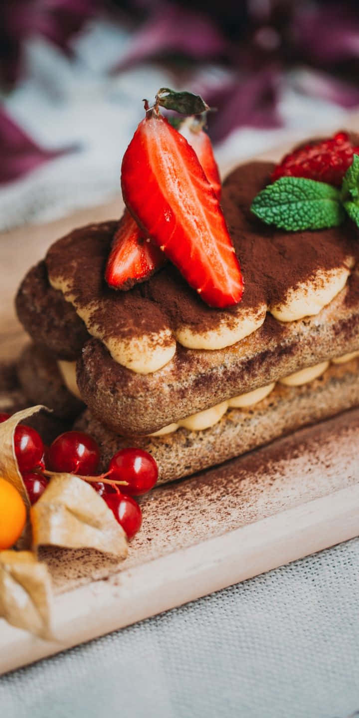 Pastry 桌布 壁紙 — 特寫鏡頭：分層提拉米蘇甜點，撒上可可粉，上面放上新鮮草莓和薄荷。