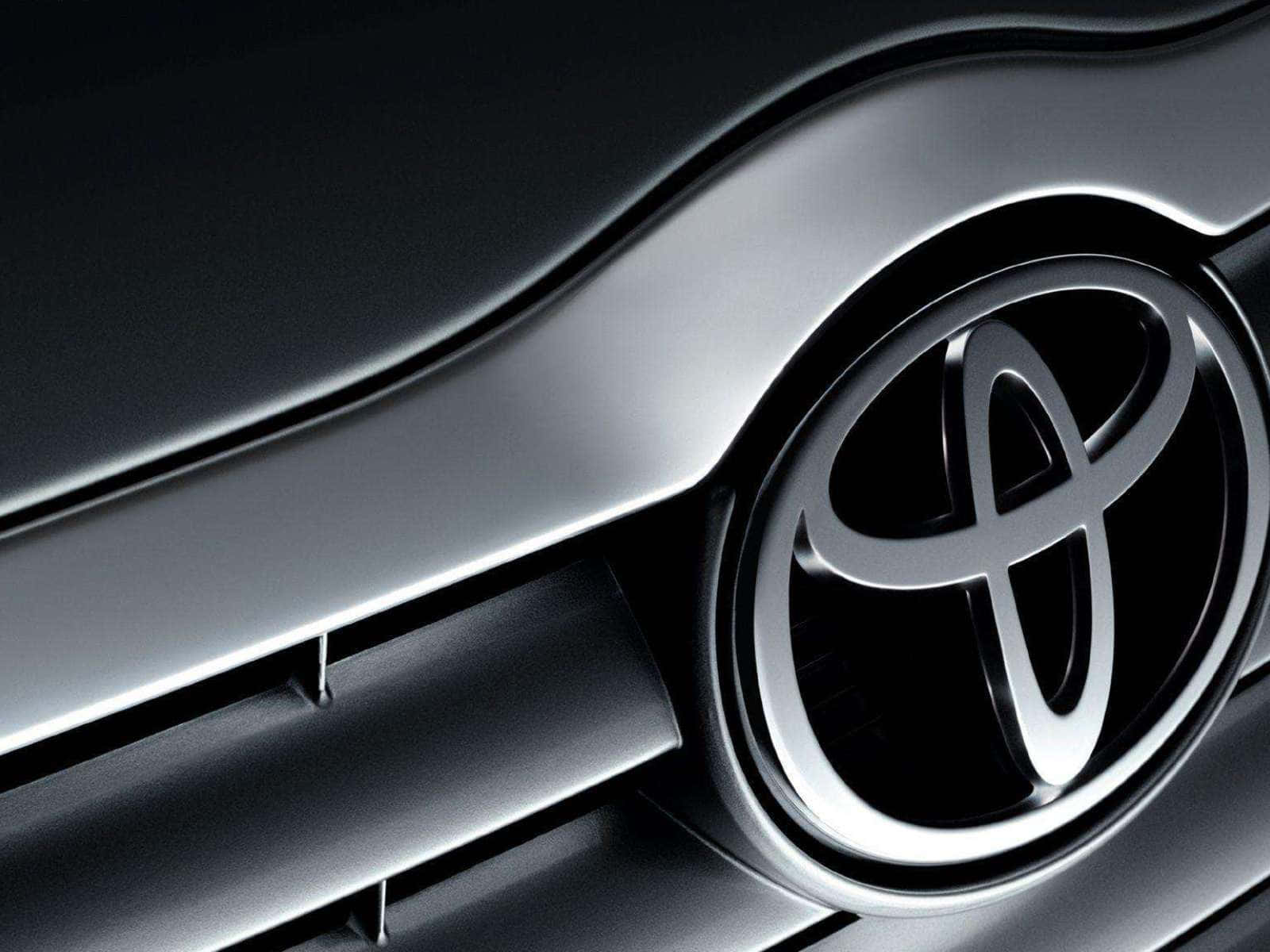 汽車格柵上帶有金屬反光的光亮豐田標誌。 — Toyota Supra Mk4 壁紙