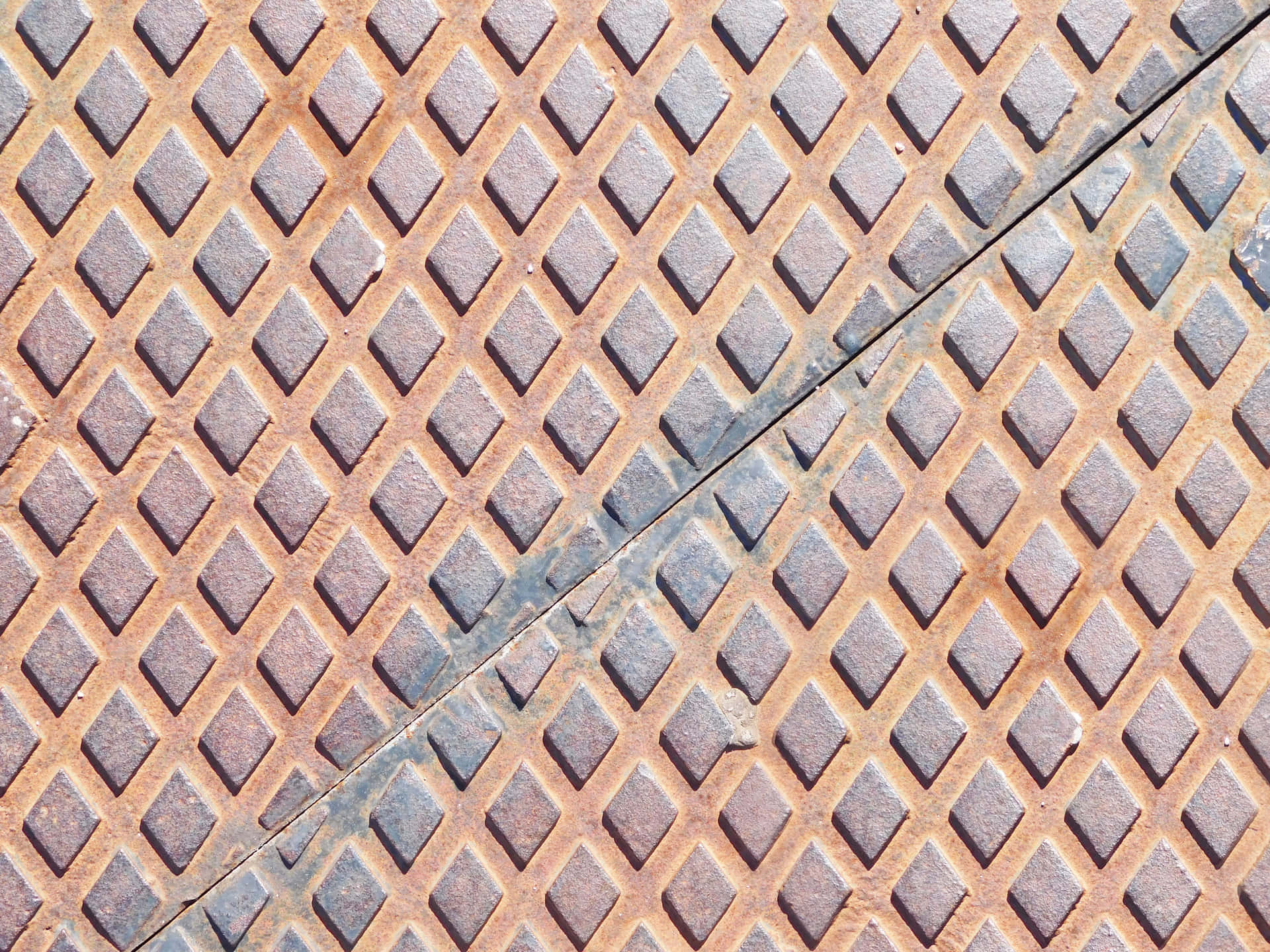 Metal texture 壁紙 — 特寫鏡頭：在明亮光線下，帶有菱形圖案和對角接縫的風化生鏽金屬格柵。