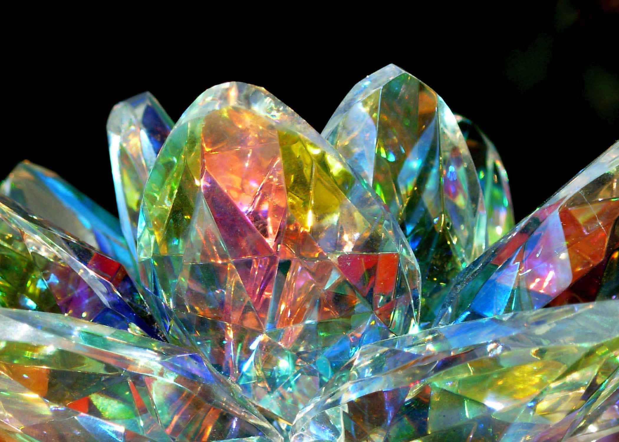 Crystal 桌布 壁紙 — 特寫鏡頭：多面水晶碎片在黑色背景下折射出鮮豔的彩虹光。