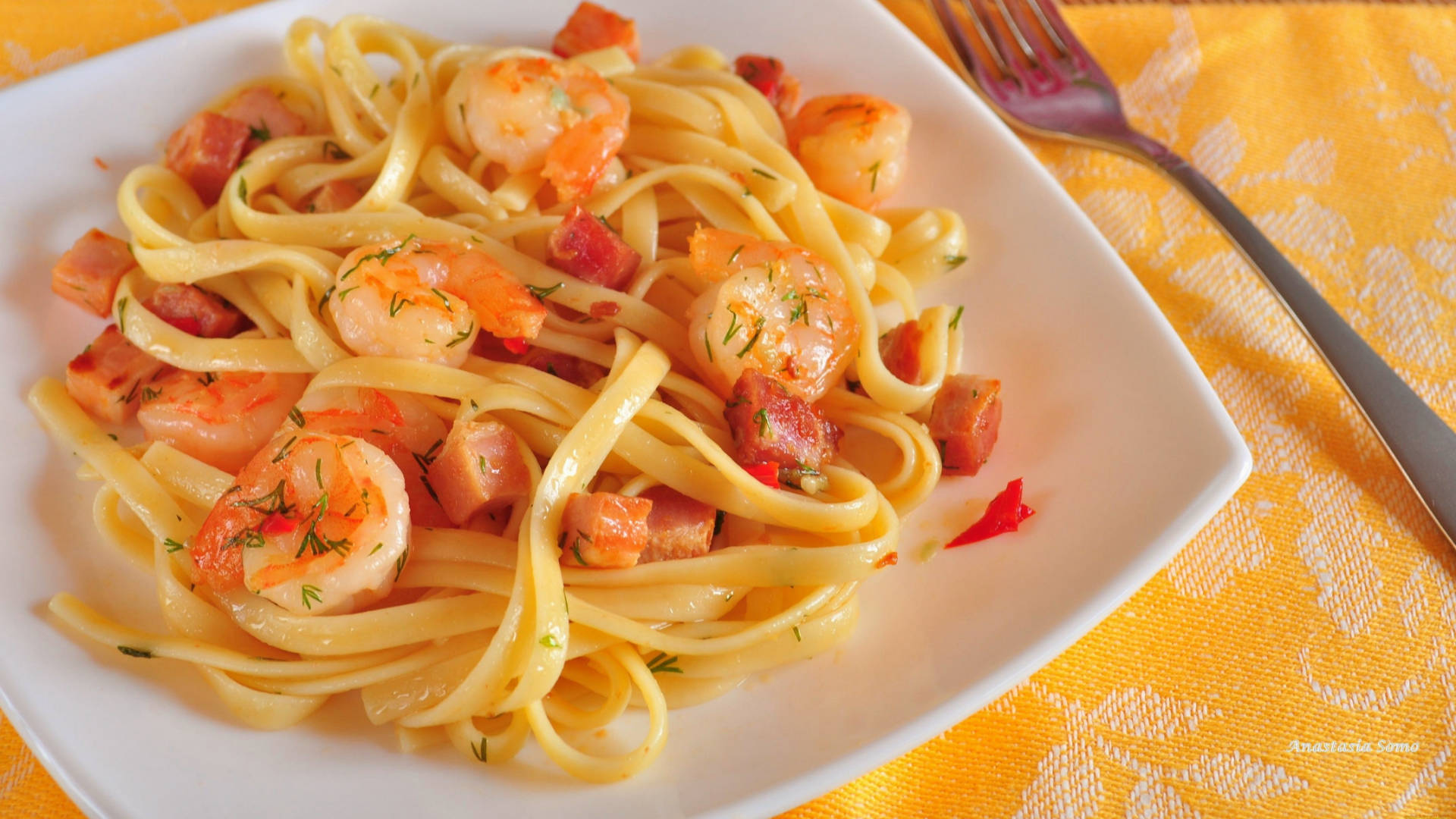 Pasta 桌布 壁紙 — 特寫鏡頭：奶油費特欽尼麵條配上多汁蝦仁和香脆培根，以新鮮蒔蘿點綴，盛載於白色碟上。