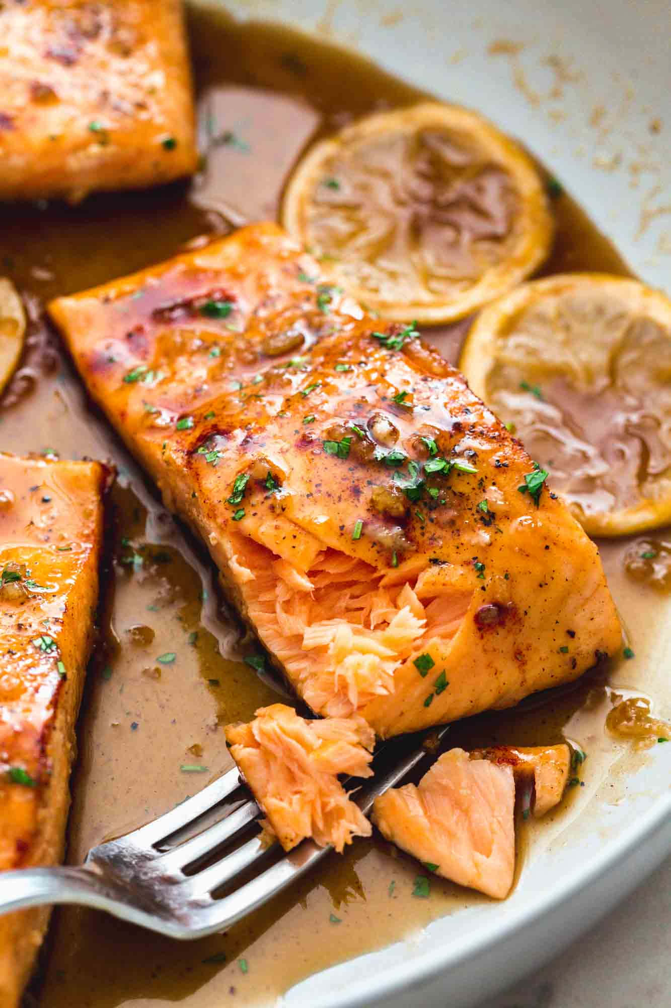 Salmon 桌布 壁紙 — 特寫鏡頭：嫩滑鮭魚柳配上濃郁醬汁，佐以檸檬片和香草，盛裝於白色碗中。