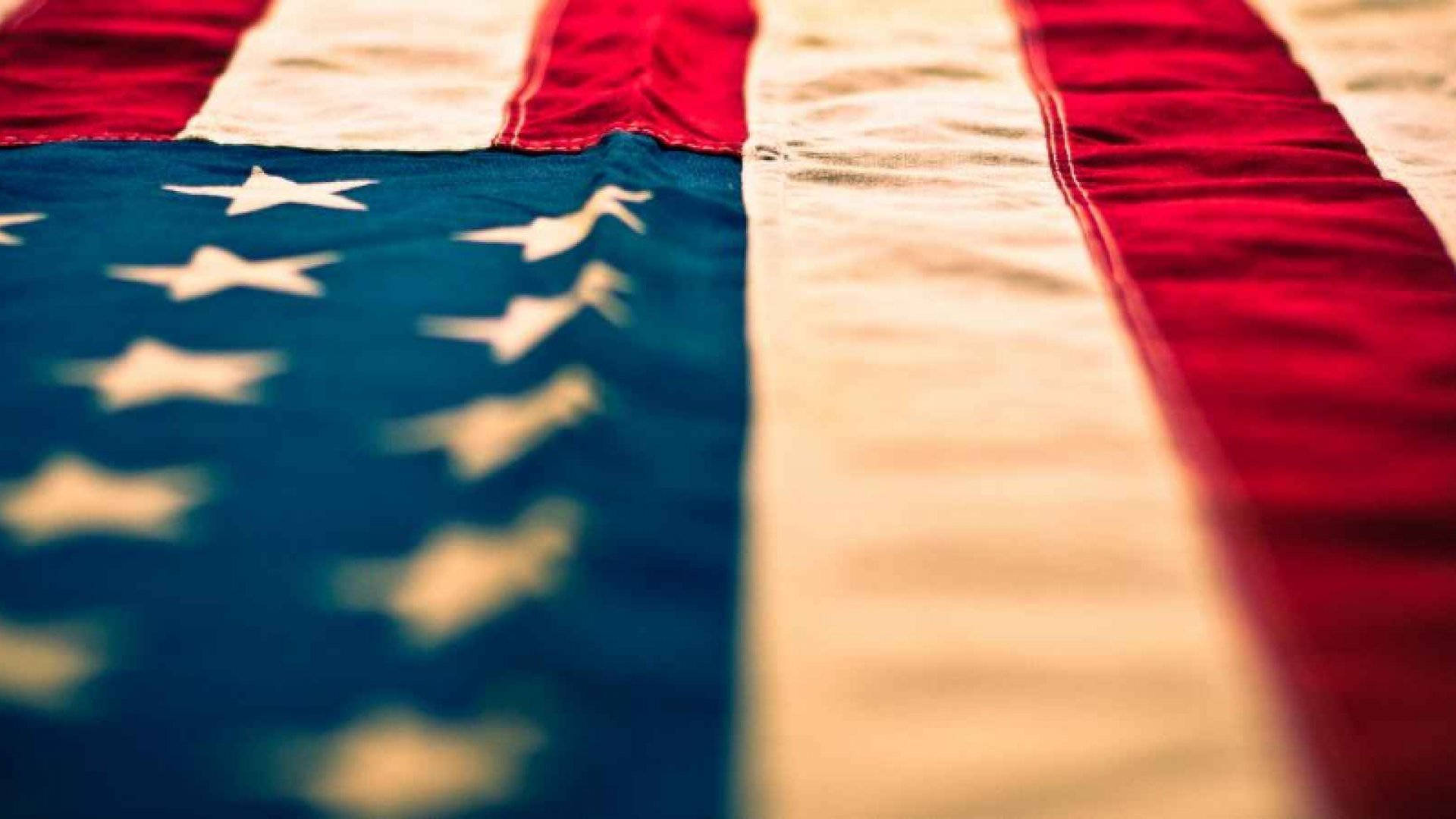 Flag 桌布 壁紙 — 特寫鏡頭，展示一面風化的美國國旗，帶有紅、白、藍條紋和星星，景深較淺。