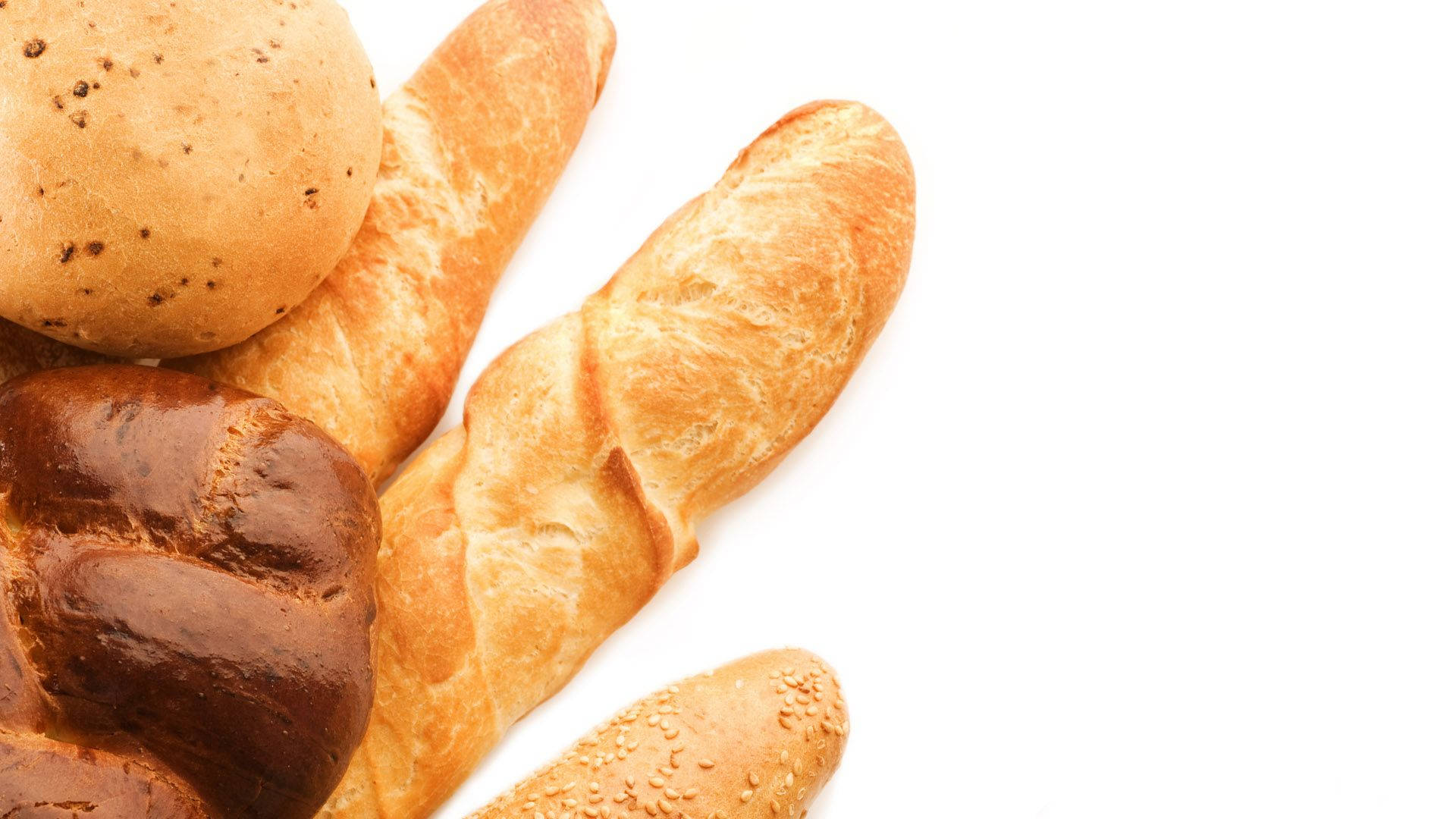 Bread 桌布 壁紙 — 特寫鏡頭，展示各種金黃色麵包，包括法式長棍麵包和帶有種子及外皮的麵包卷，背景為純白色。