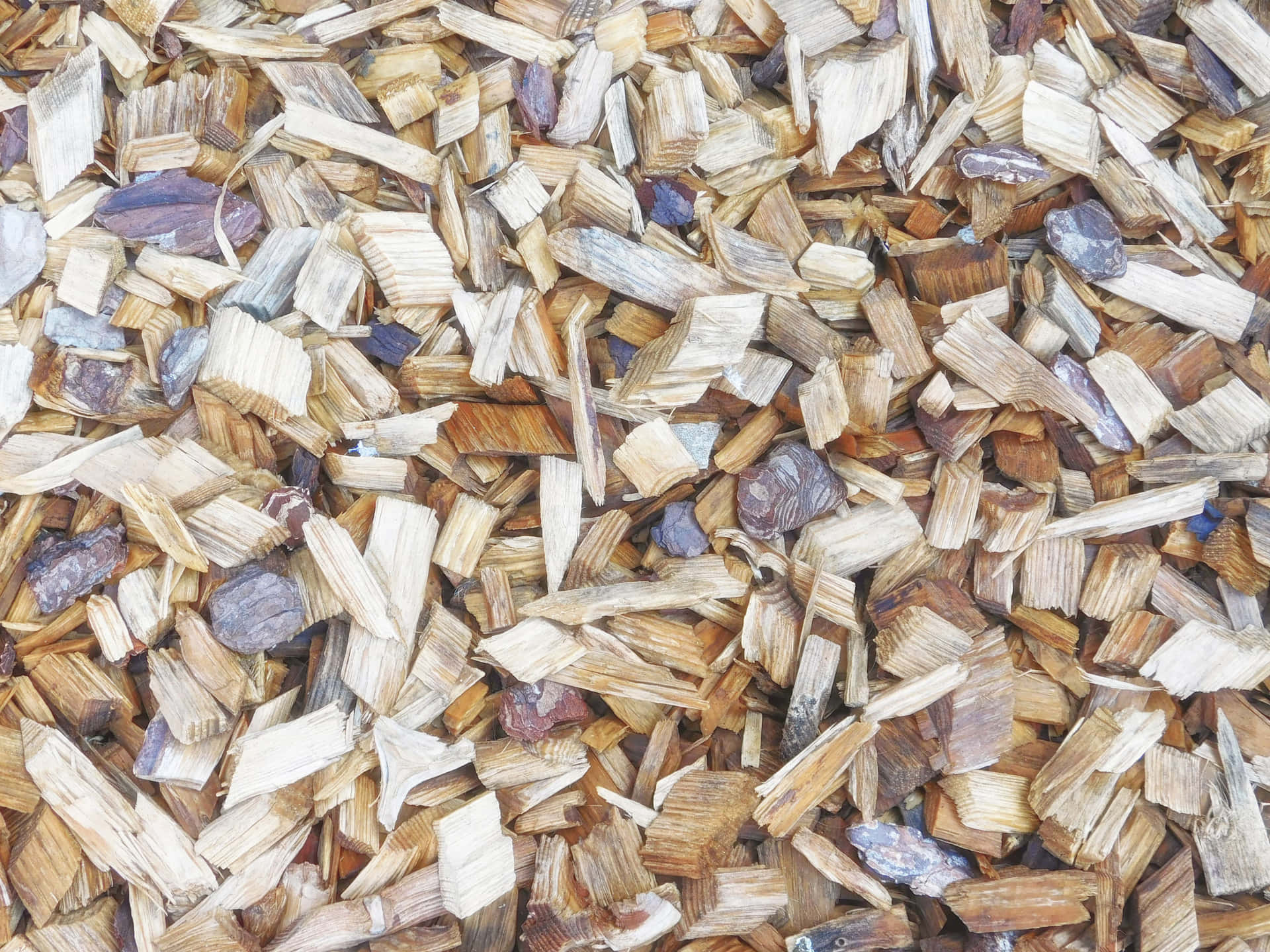 Wood texture 壁紙 — 特寫鏡頭，展示散落的木屑和小石頭，呈現大地色調，形成有紋理的自然地面覆蓋物。