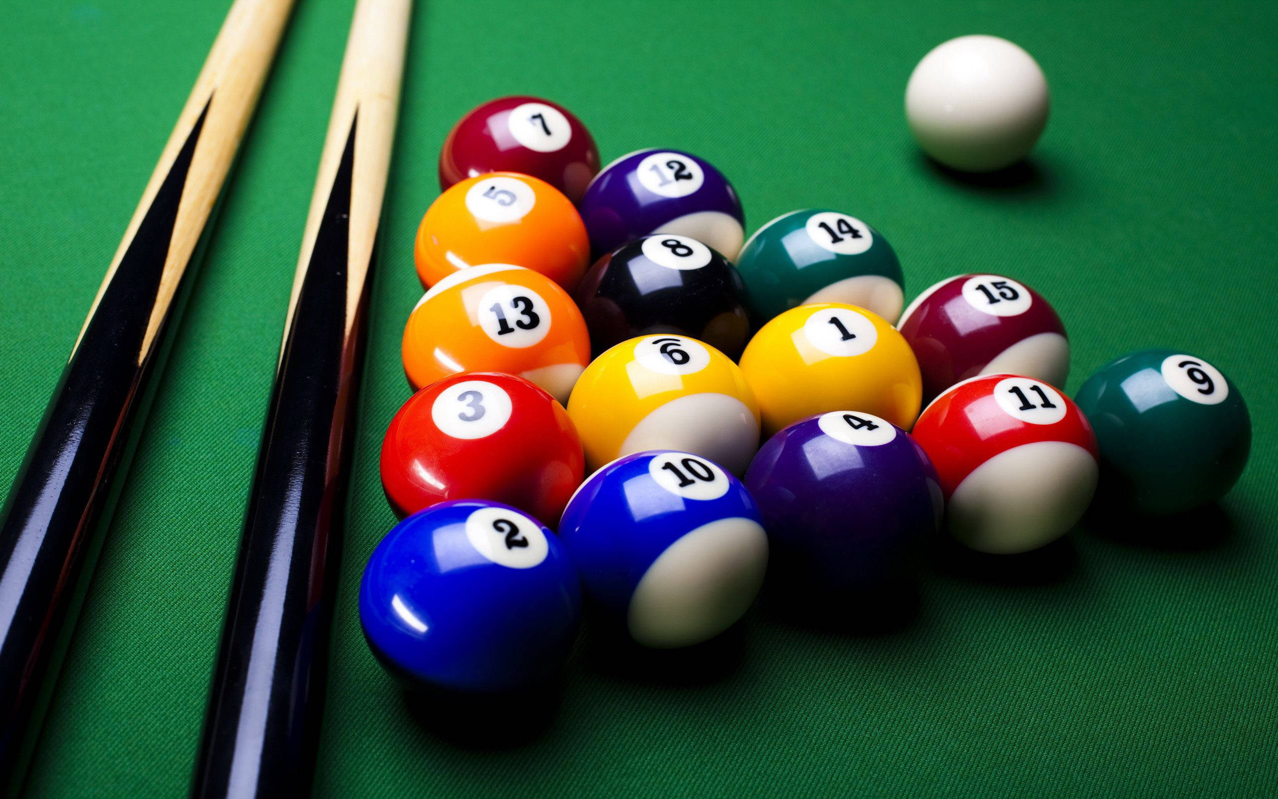 Snooker 桌布 壁紙 — 特寫鏡頭，彩色撞球在綠色絨布桌上排列成三角形，附近有兩支球桿擱置。