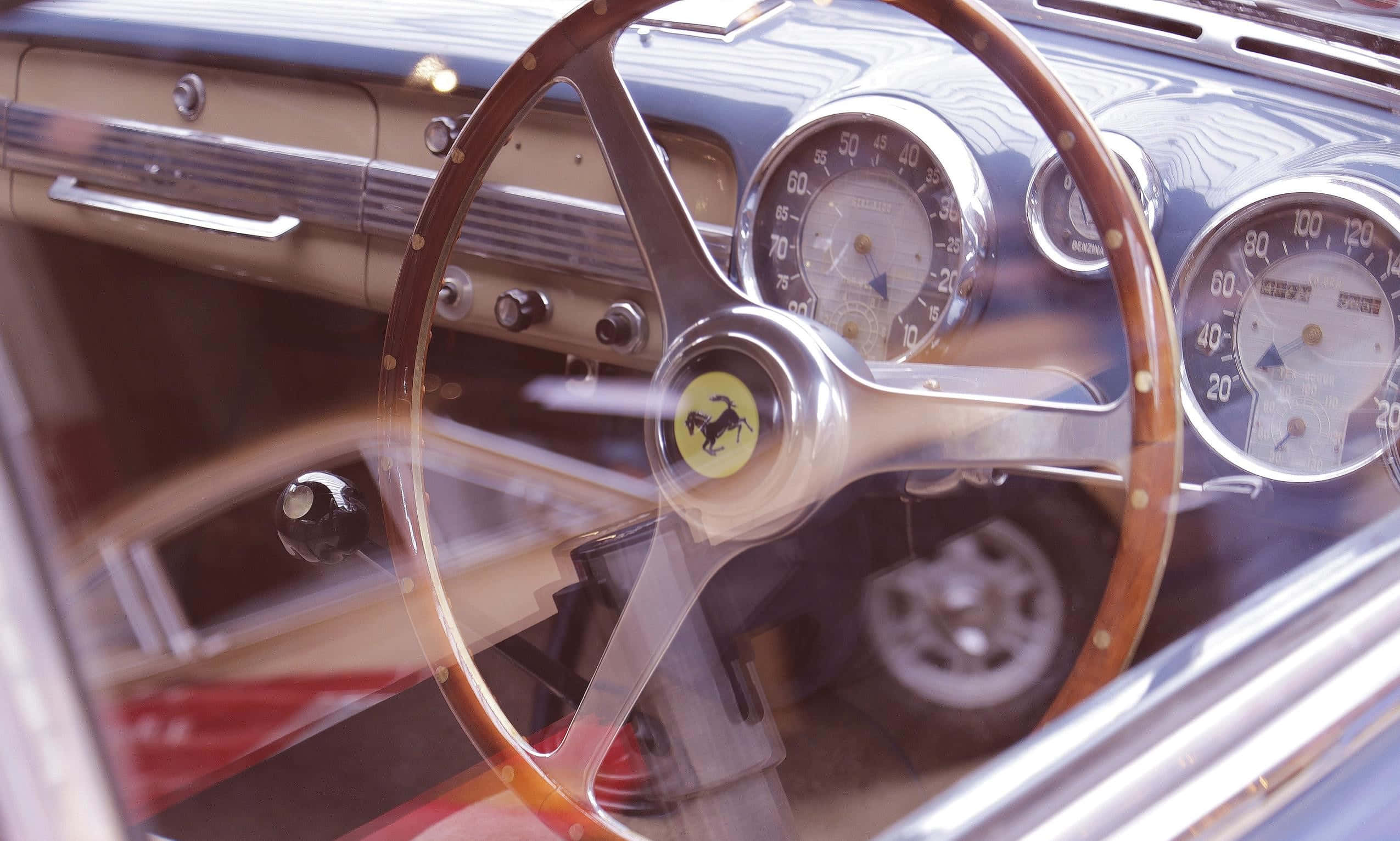 Steering Wheel 桌布 壁紙 — 特寫鏡頭：復古法拉利儀表板，配備木質方向盤和鍍鉻儀表，在明亮陽光下拍攝。