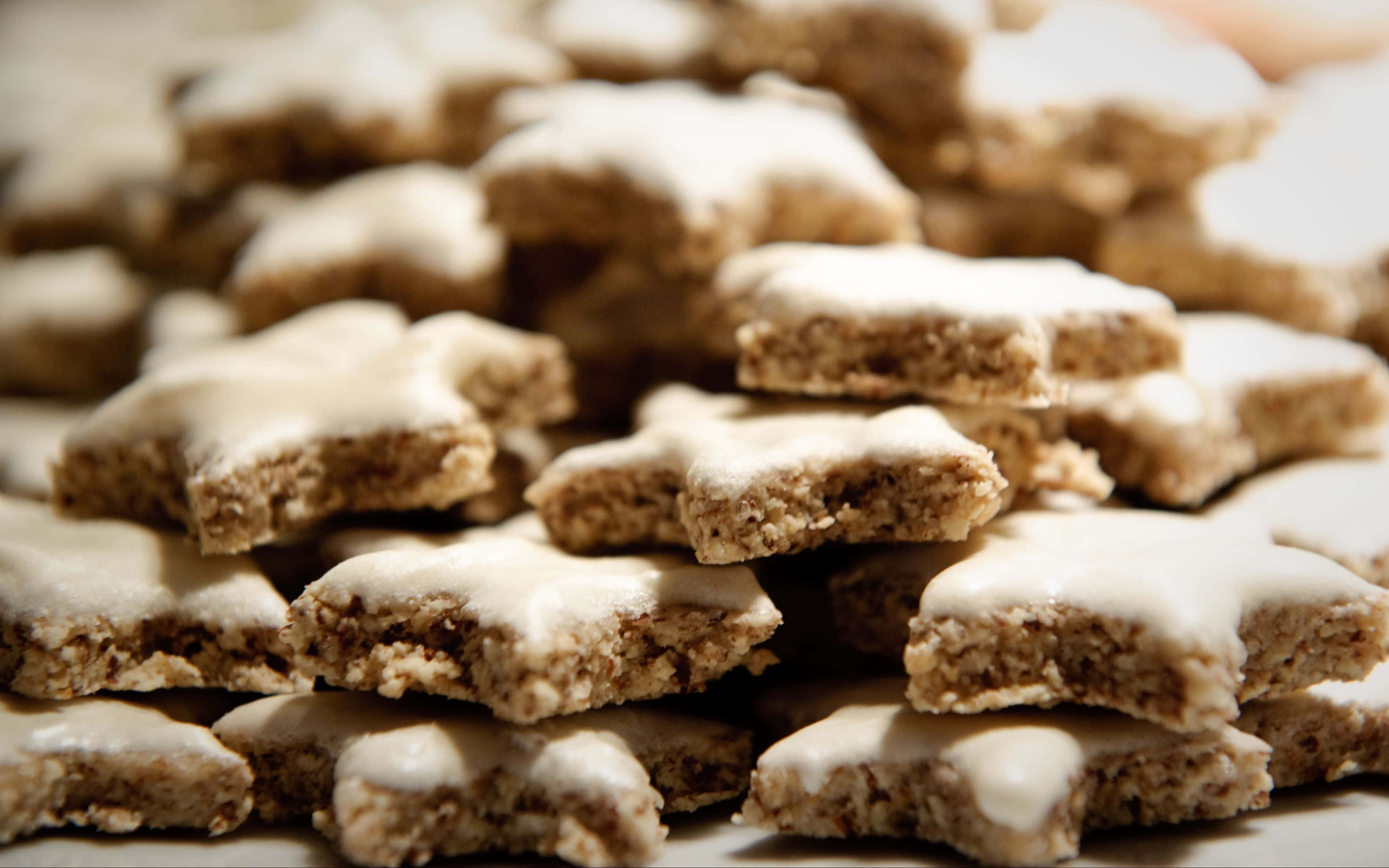 Cookies 桌布 壁紙 — 特寫鏡頭：星形燕麥餅乾，上面有白色糖霜，堆成溫暖誘人的一堆。