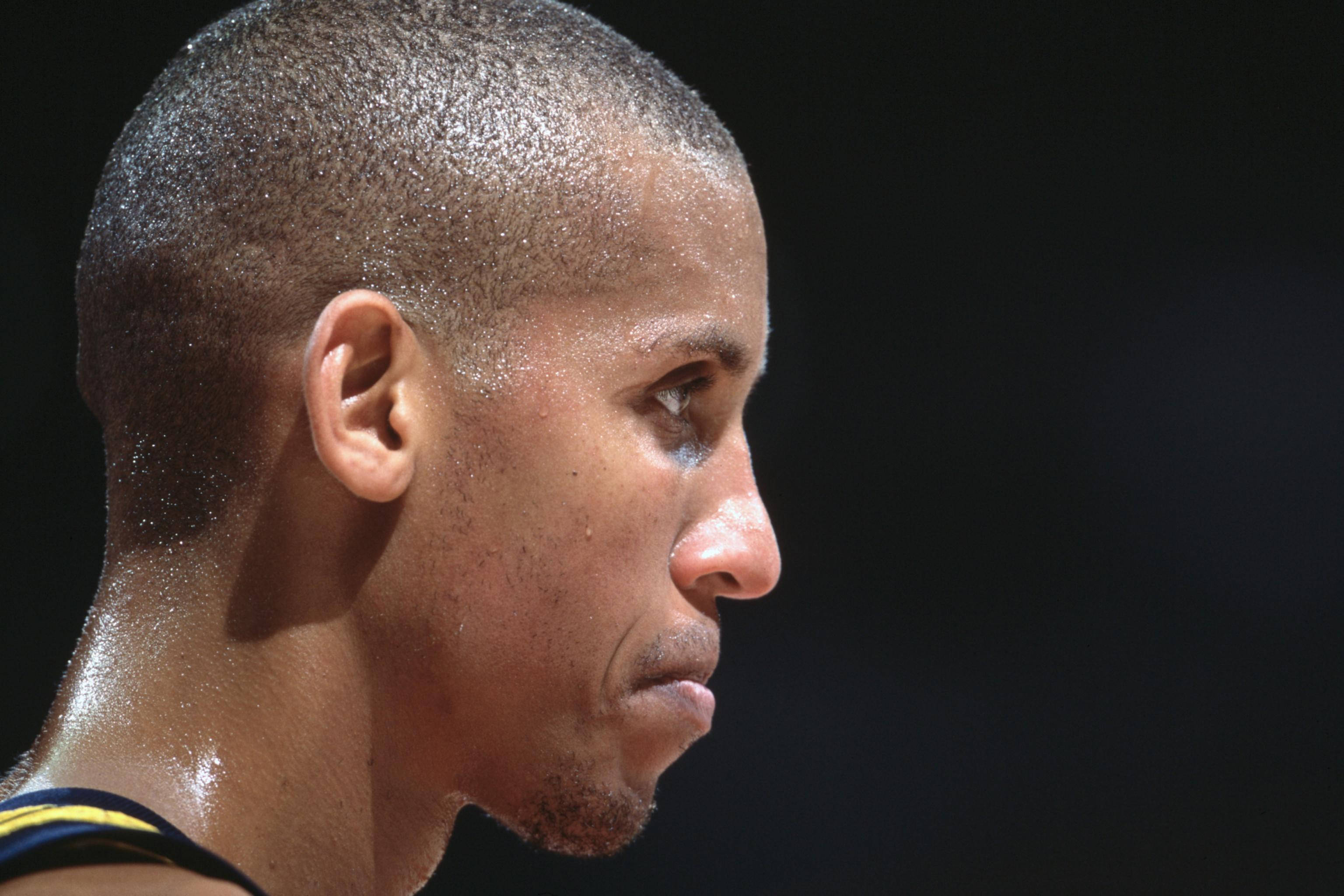 NBA 桌布 壁紙 — 特寫鏡頭：汗流浹背的籃球運動員在黑暗背景下的專注側面。
