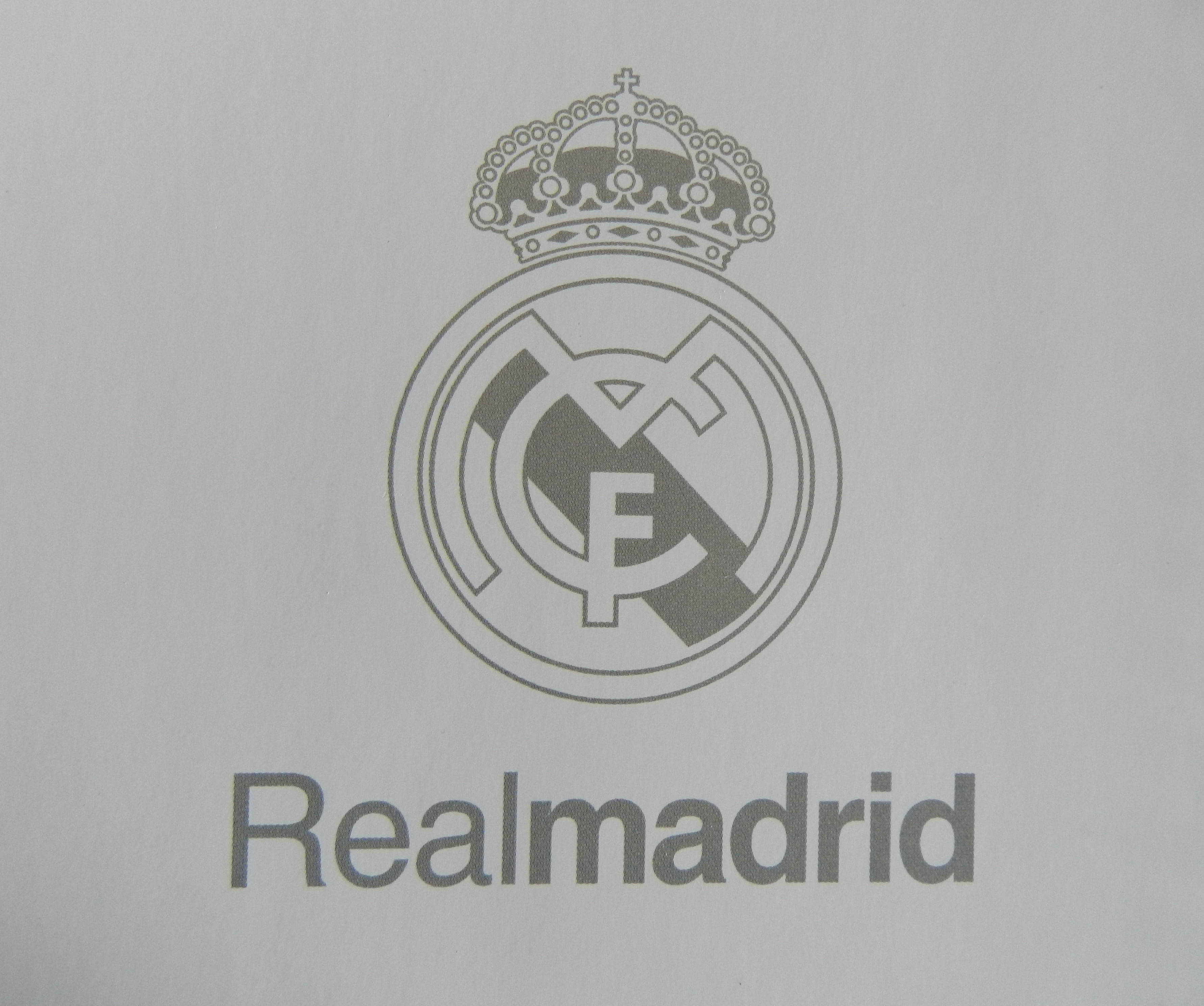 Real Madrid 4K 桌布 壁紙 — 特寫鏡頭：灰色印刷的皇家馬德里標誌，印在有紋理的白色紙上，下方有「Realmadrid」字樣。