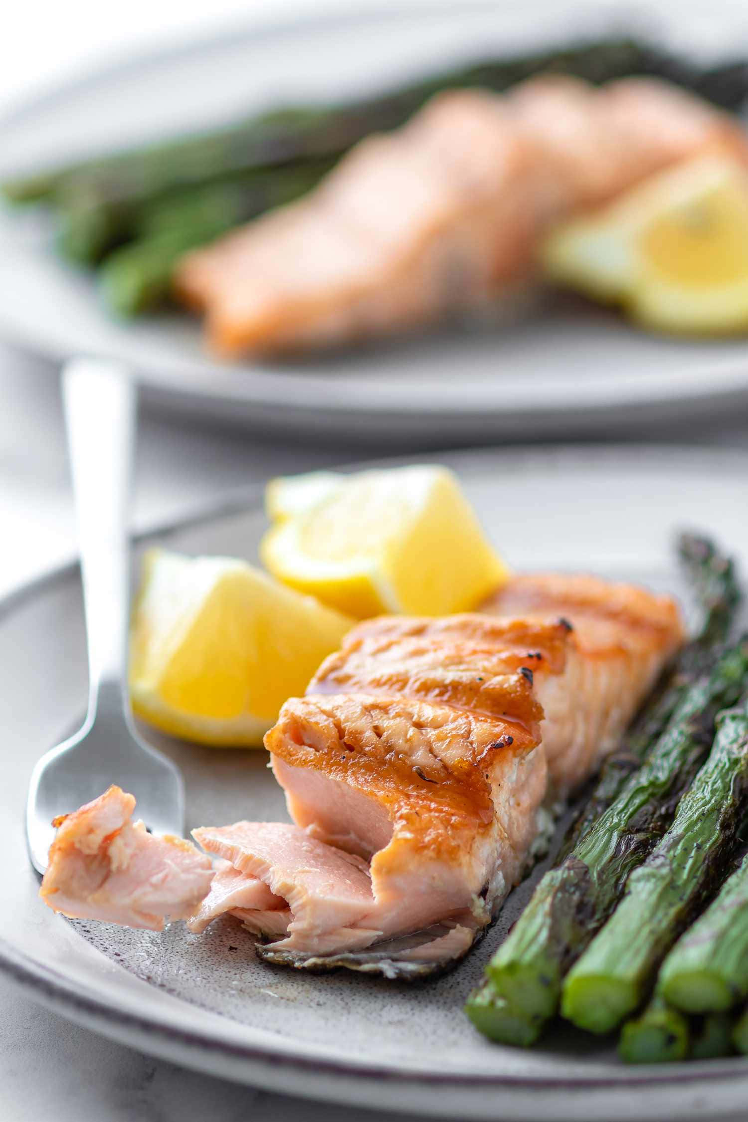Salmon 桌布 壁紙 — 特寫鏡頭：烤鮭魚配檸檬角及蘆筍，置於灰色盤子上，附有叉子。