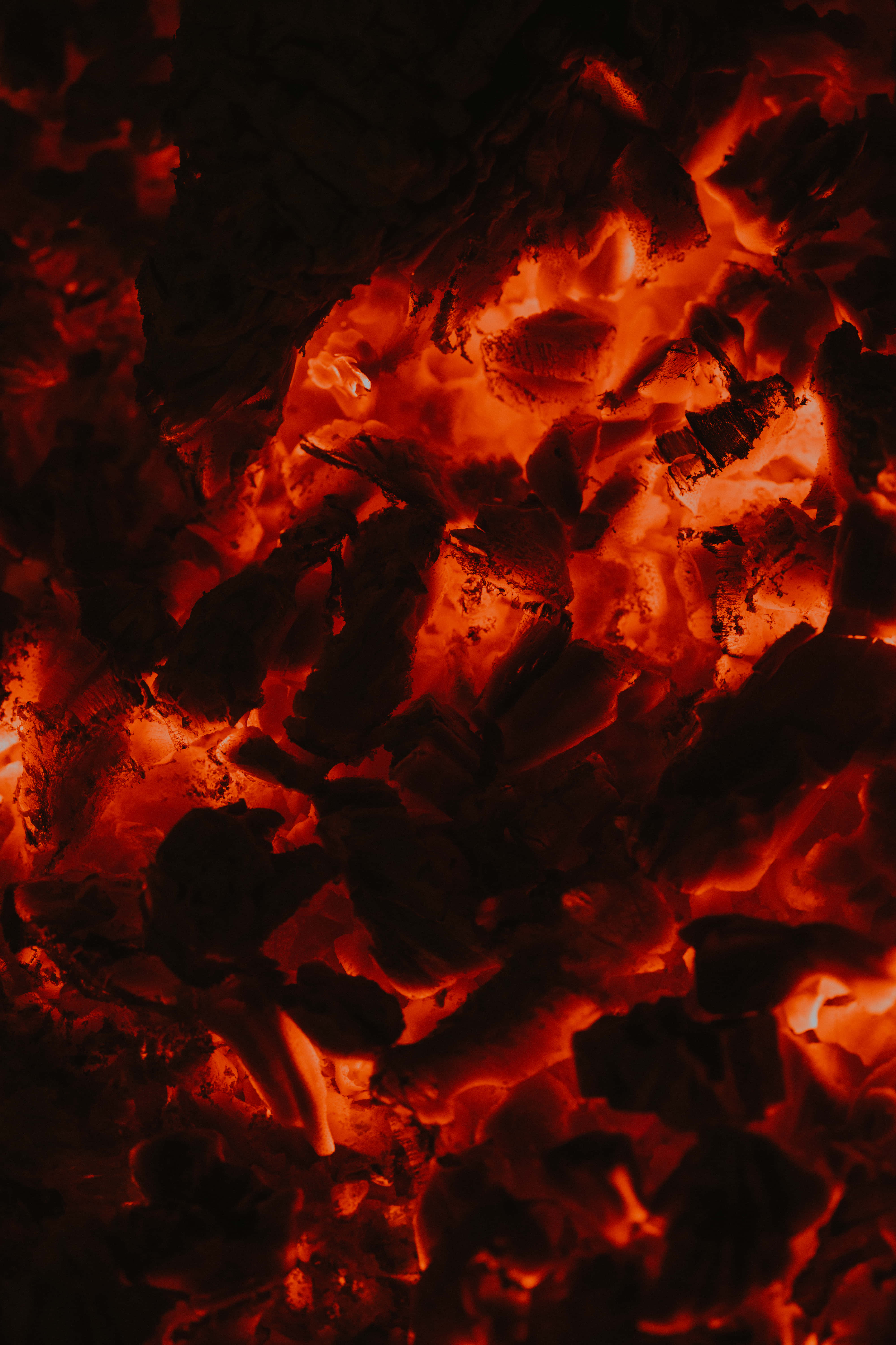 Red Fire 桌布 壁紙 — 特寫鏡頭：熾熱餘燼在深色灰燼中散發出強烈的橙色熱力。